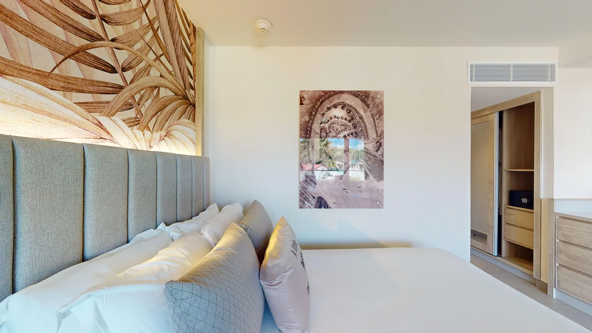 Luxury Ocean View Room king bed, wall art, and closet at Royalton CHIC Antigua.
