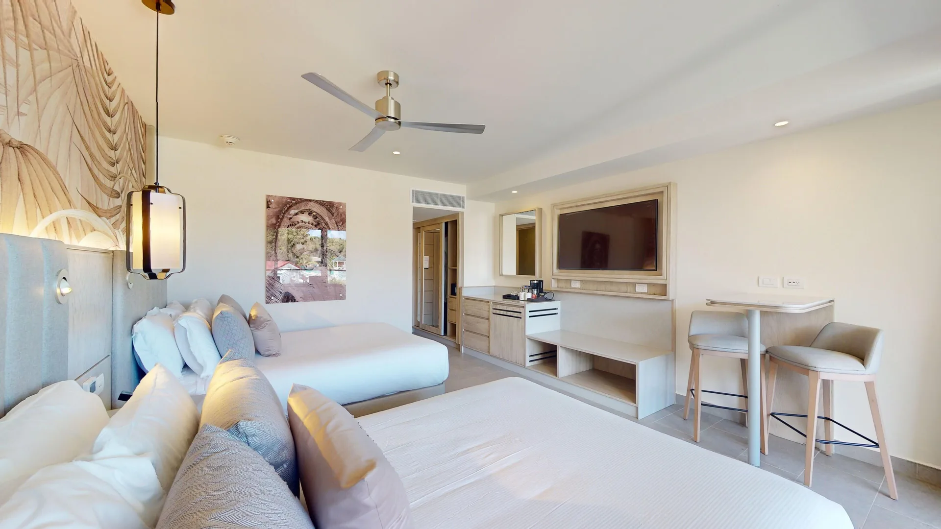 Luxury Ocean View Room with two beds, desk, and TV at Royalton CHIC Antigua.