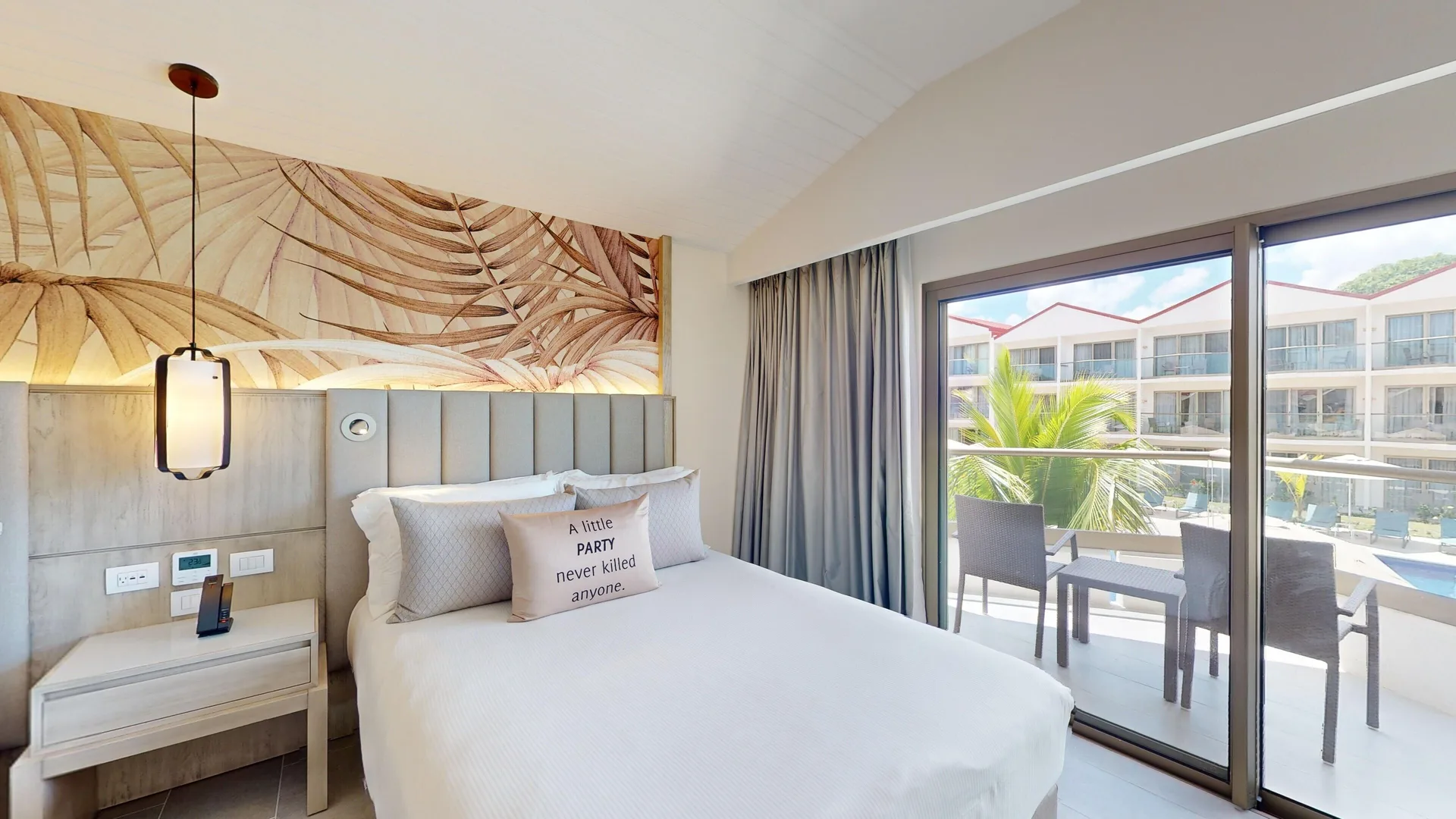Luxury Pool View Room king bed beside balcony doors at Royalton CHIC Antigua.