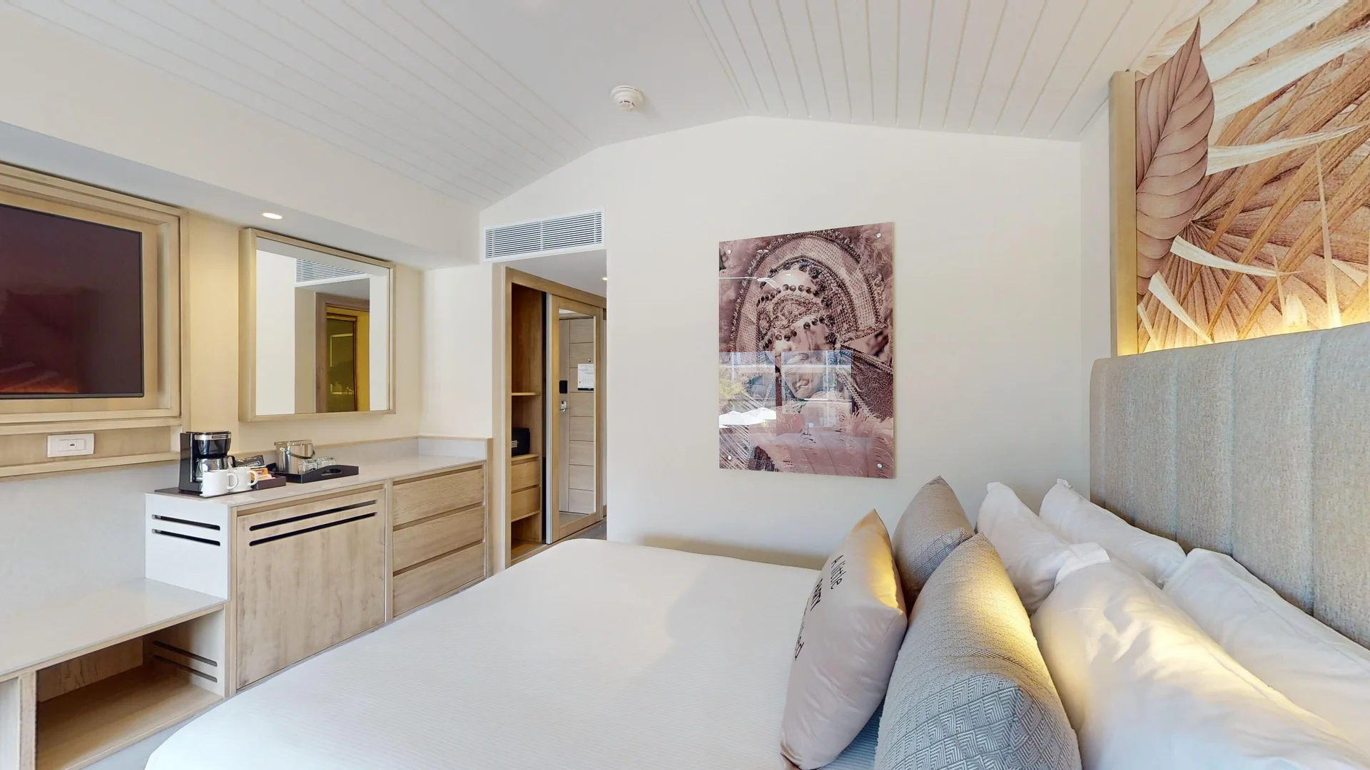 Luxury Pool View Room bed, TV, mirror, and beverage counter at Royalton CHIC Antigua.