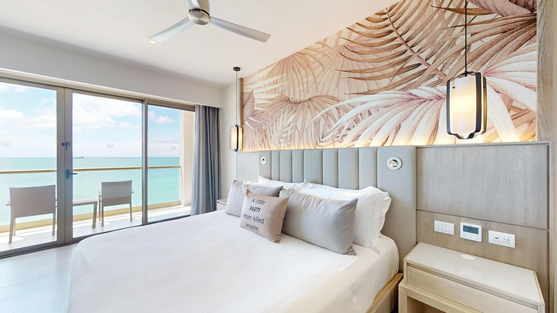 King bed beside balcony doors in a suite at Royalton CHIC Antigua.