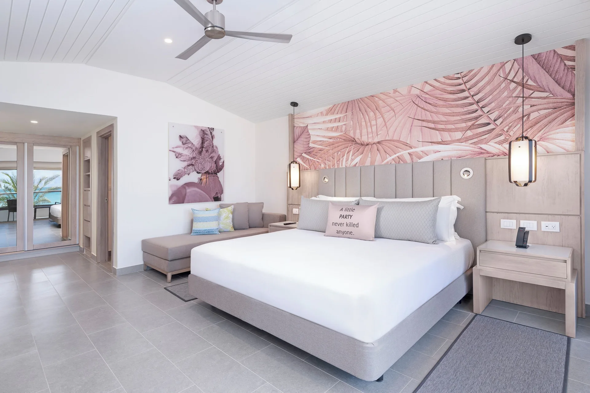 Suite bedroom with king bed and lounge seating at Royalton CHIC Antigua.