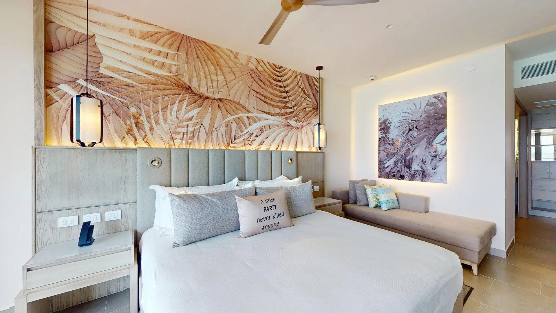 King bed and chaise in a beachfront one-bedroom suite at Royalton CHIC Antigua.