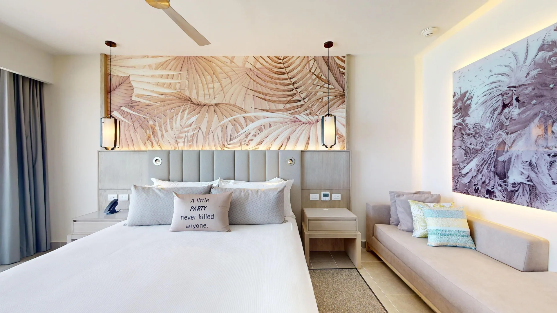 Suite bedroom with king bed and sofa at Royalton CHIC Antigua.
