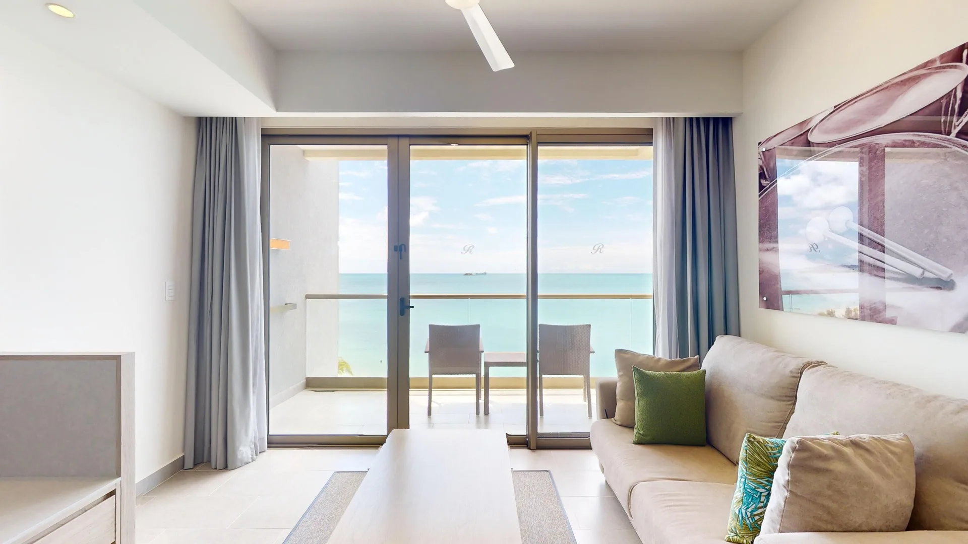 Suite sitting area with sofa and ocean-facing balcony at Royalton CHIC Antigua.