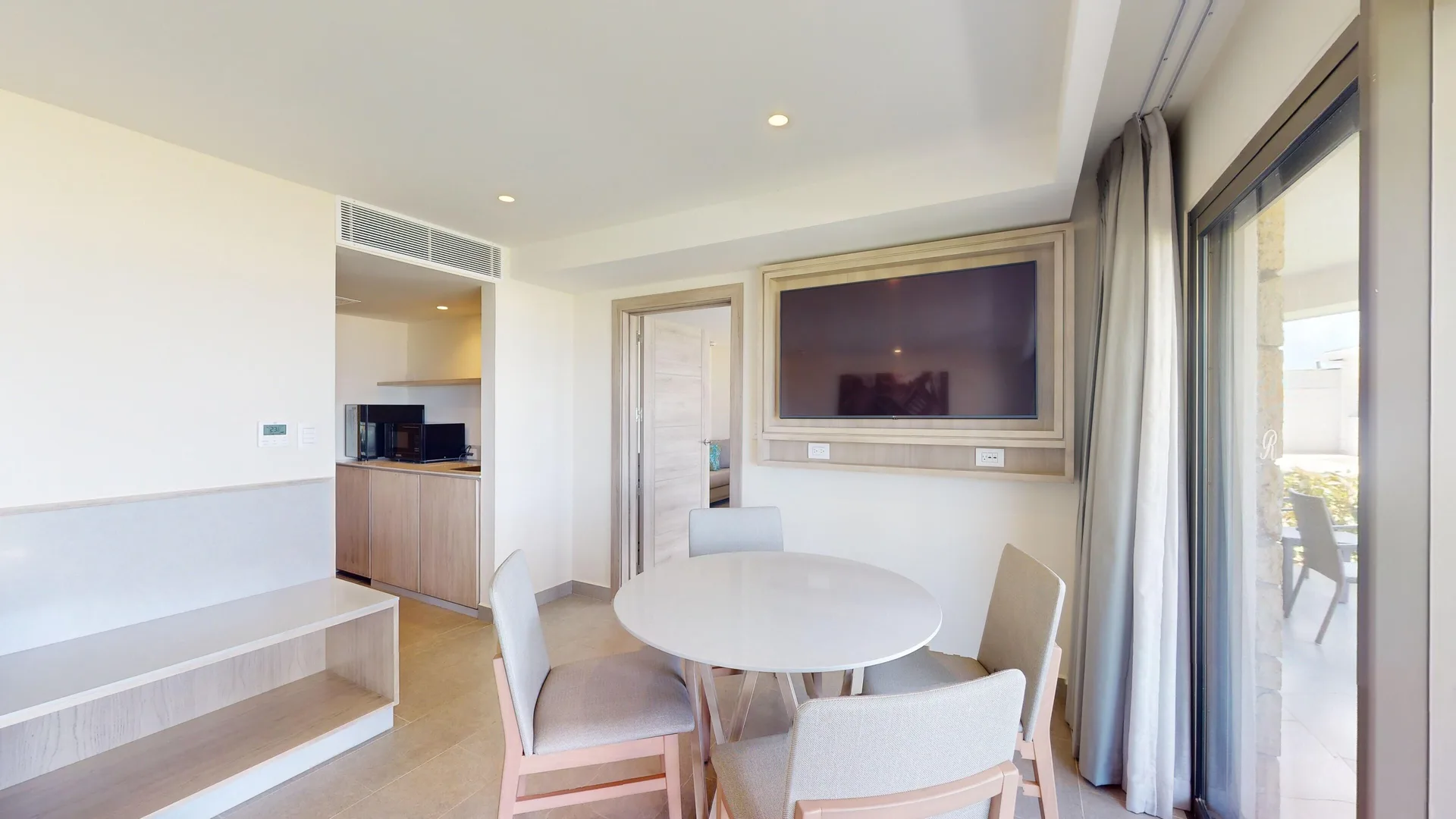 Presidential suite dining table and wall TV at Royalton CHIC Antigua.