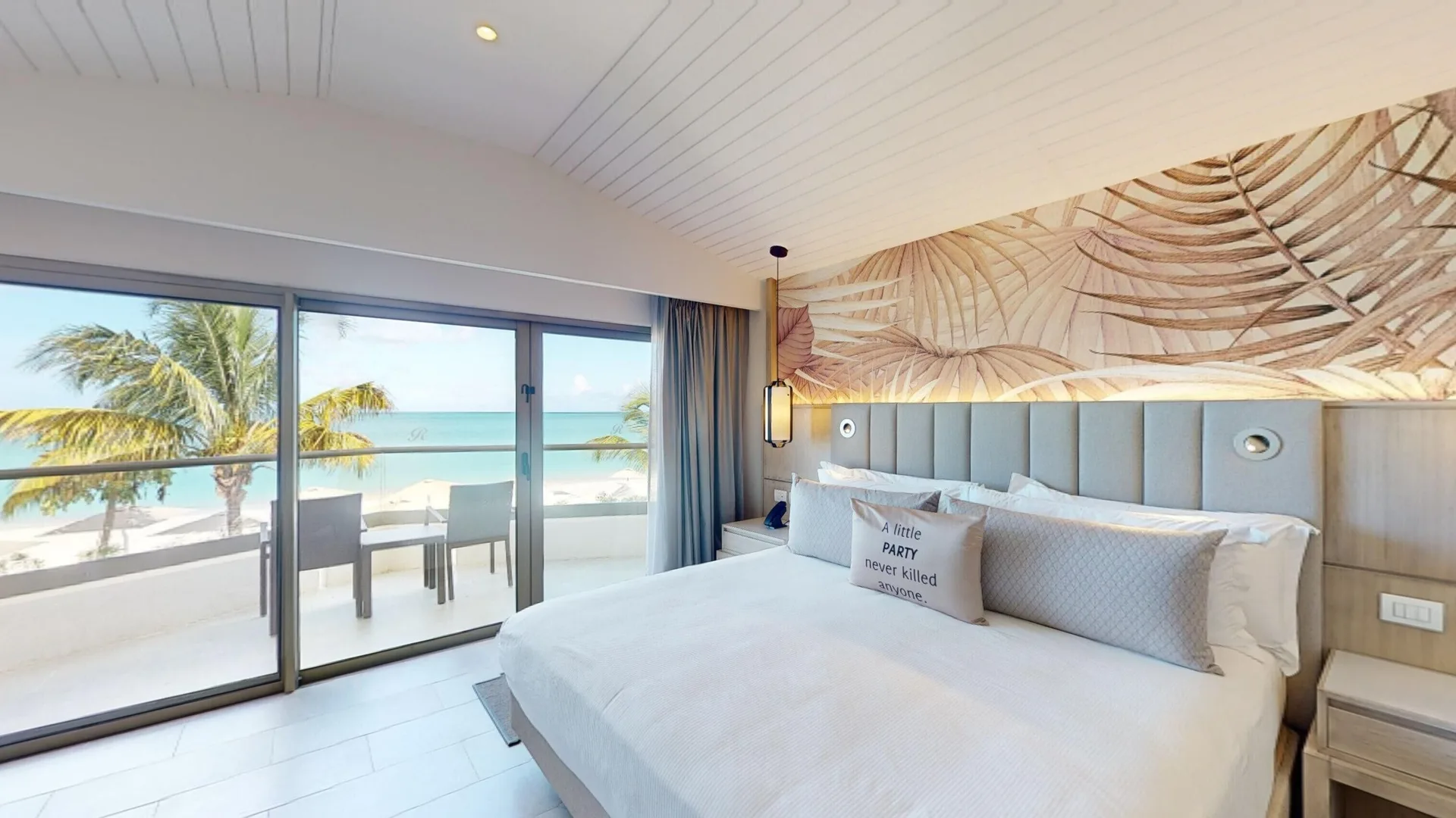 King bed facing a balcony with ocean and palm views at Royalton CHIC Antigua.
