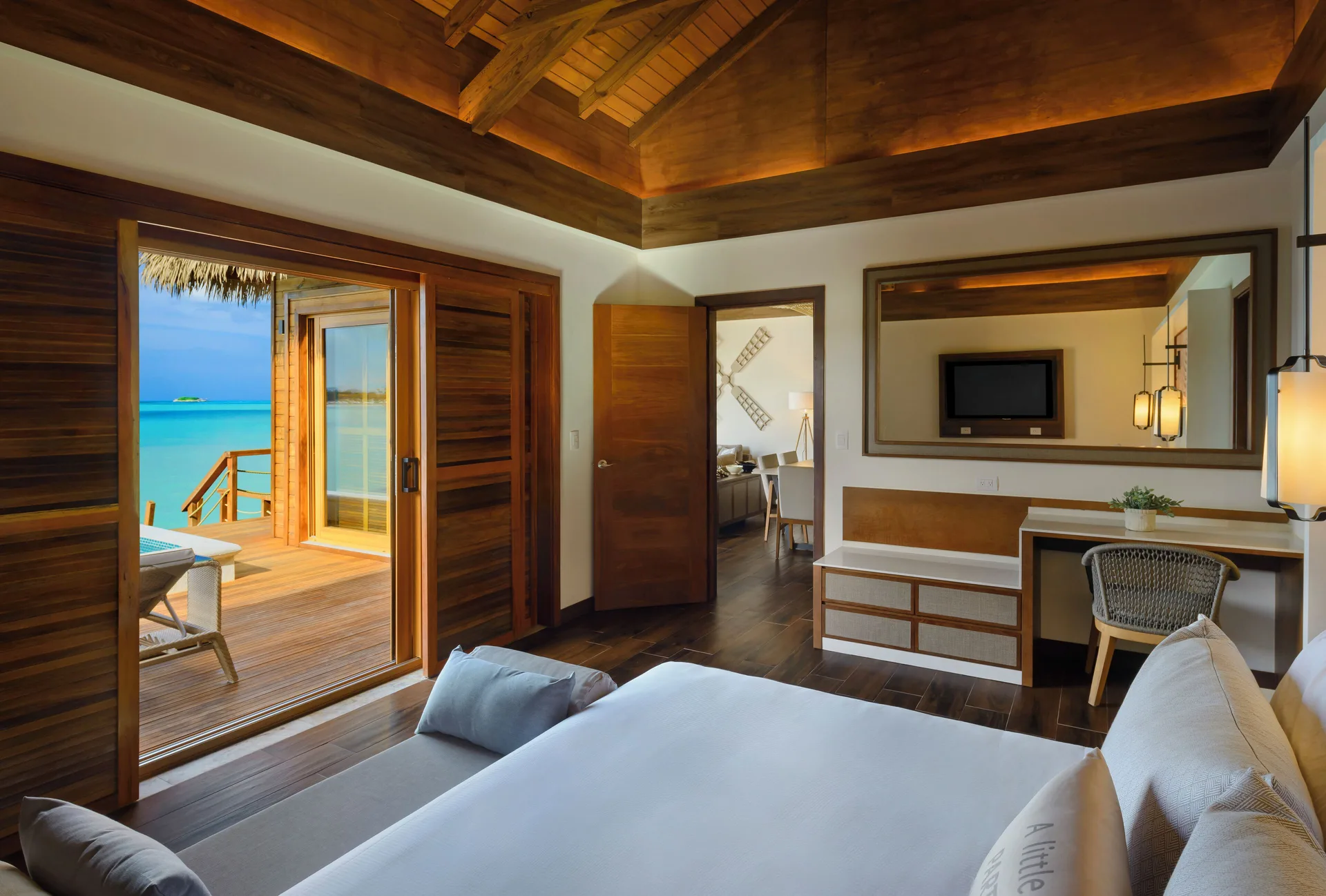 Bedroom in an overwater suite at Royalton CHIC Antigua with a king bed and deck access.