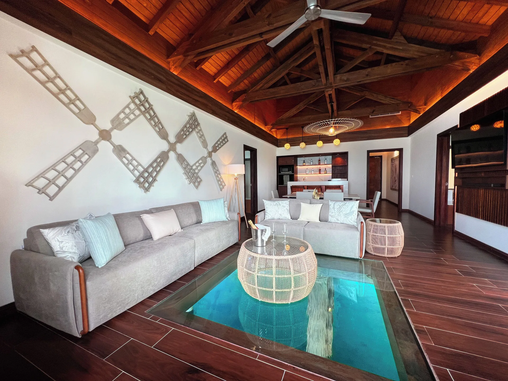 Living room of an overwater suite at Royalton CHIC Antigua with sofas and a glass floor panel.