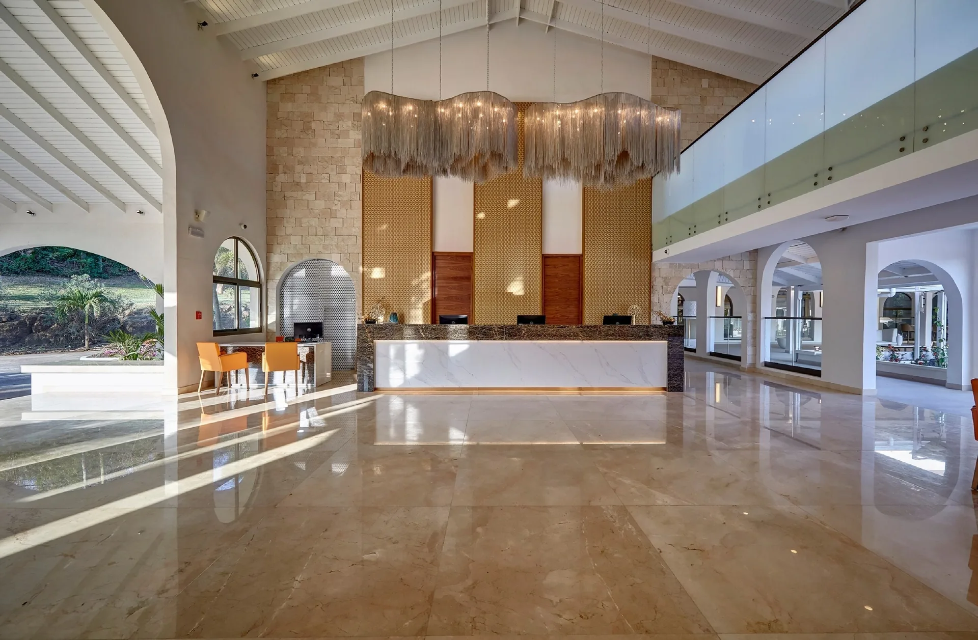 Front-facing lobby reception desk and chandelier at Royalton Grenada.