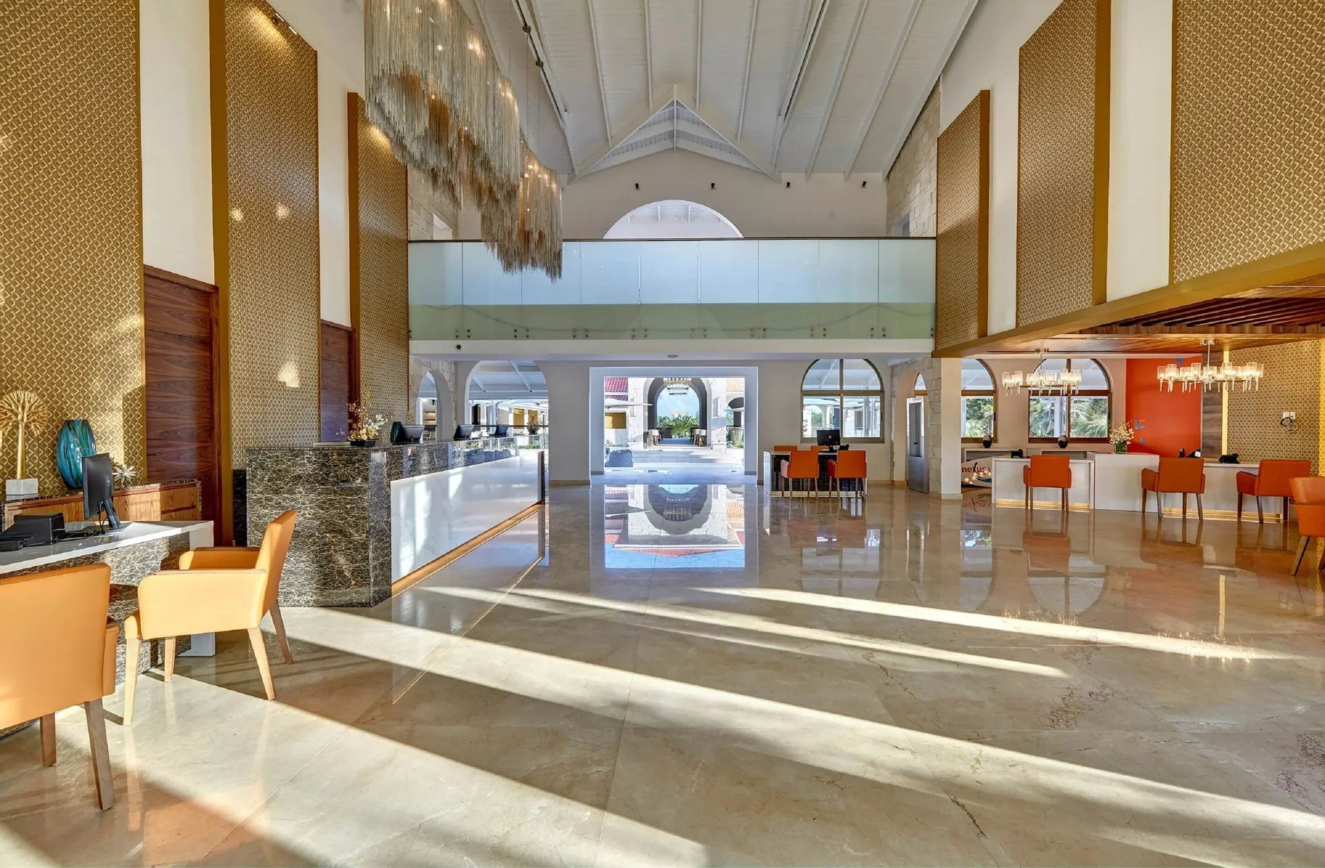 Lobby lounge with reception counters and orange seating at Royalton Grenada.