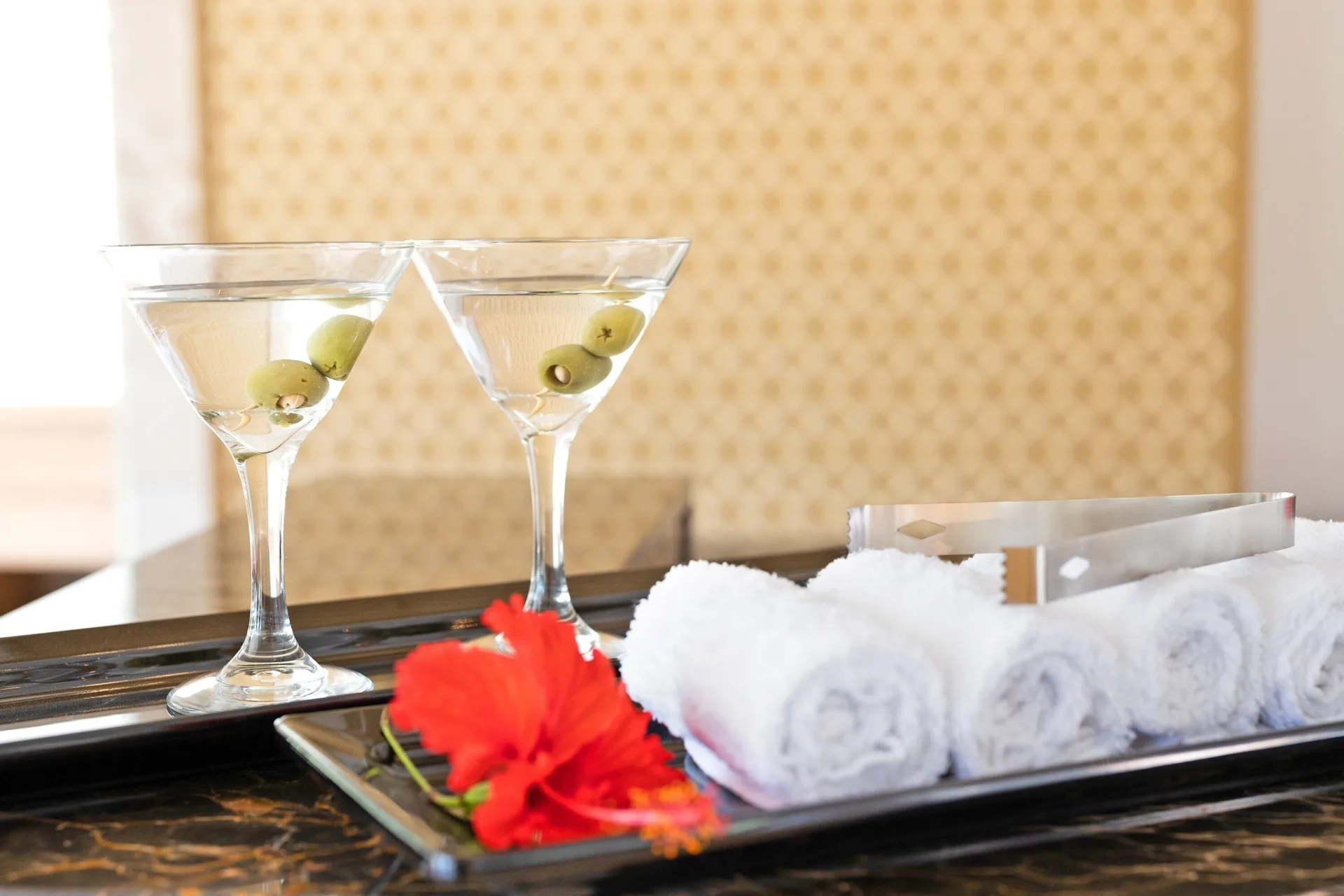Two martini glasses, rolled towels, and a red flower at Royalton Grenada.
