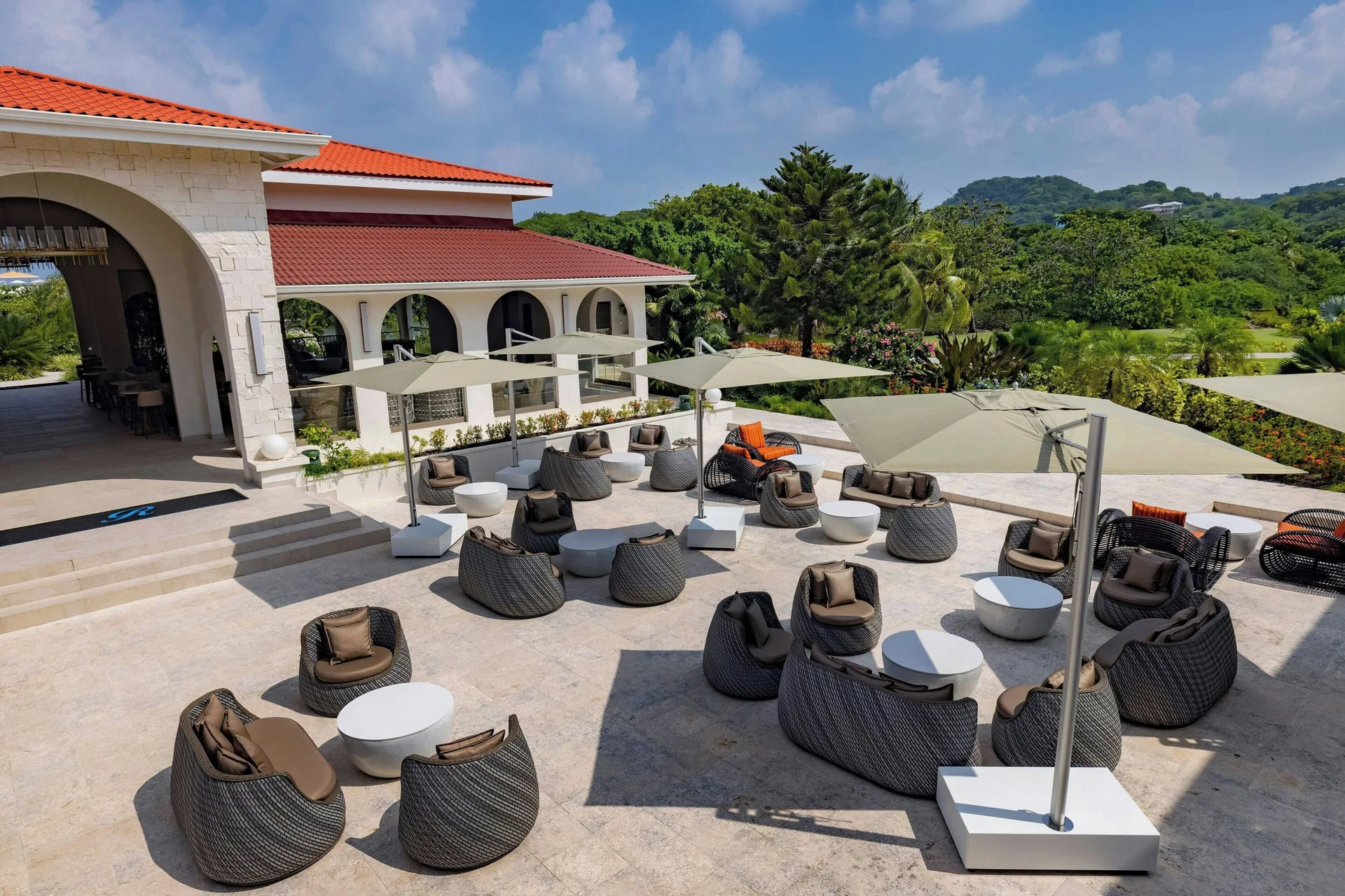 Outdoor terrace lounge with umbrellas and wicker chairs at Royalton Grenada.