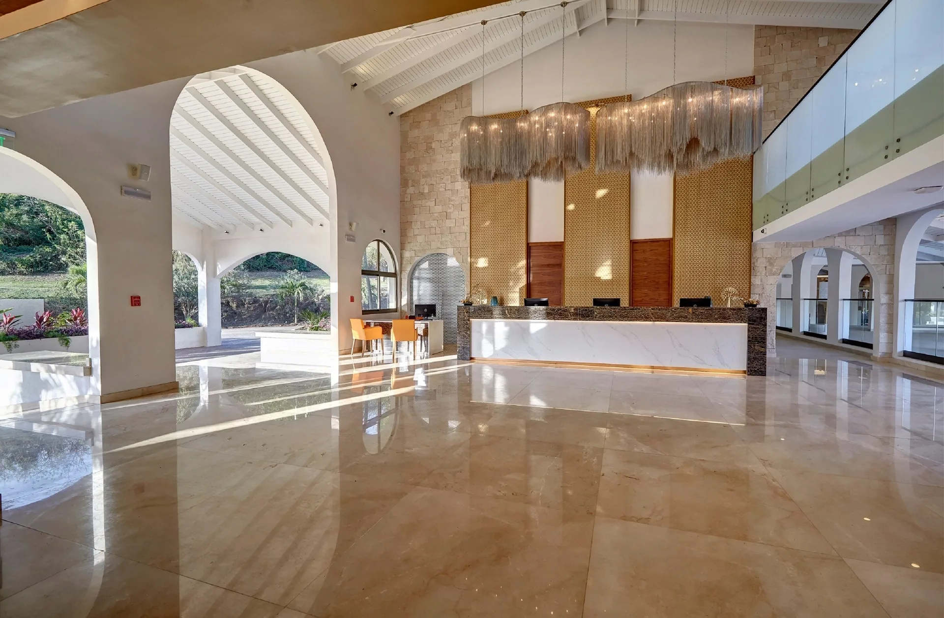 Sunlit lobby reception area with arched openings at Royalton Grenada.