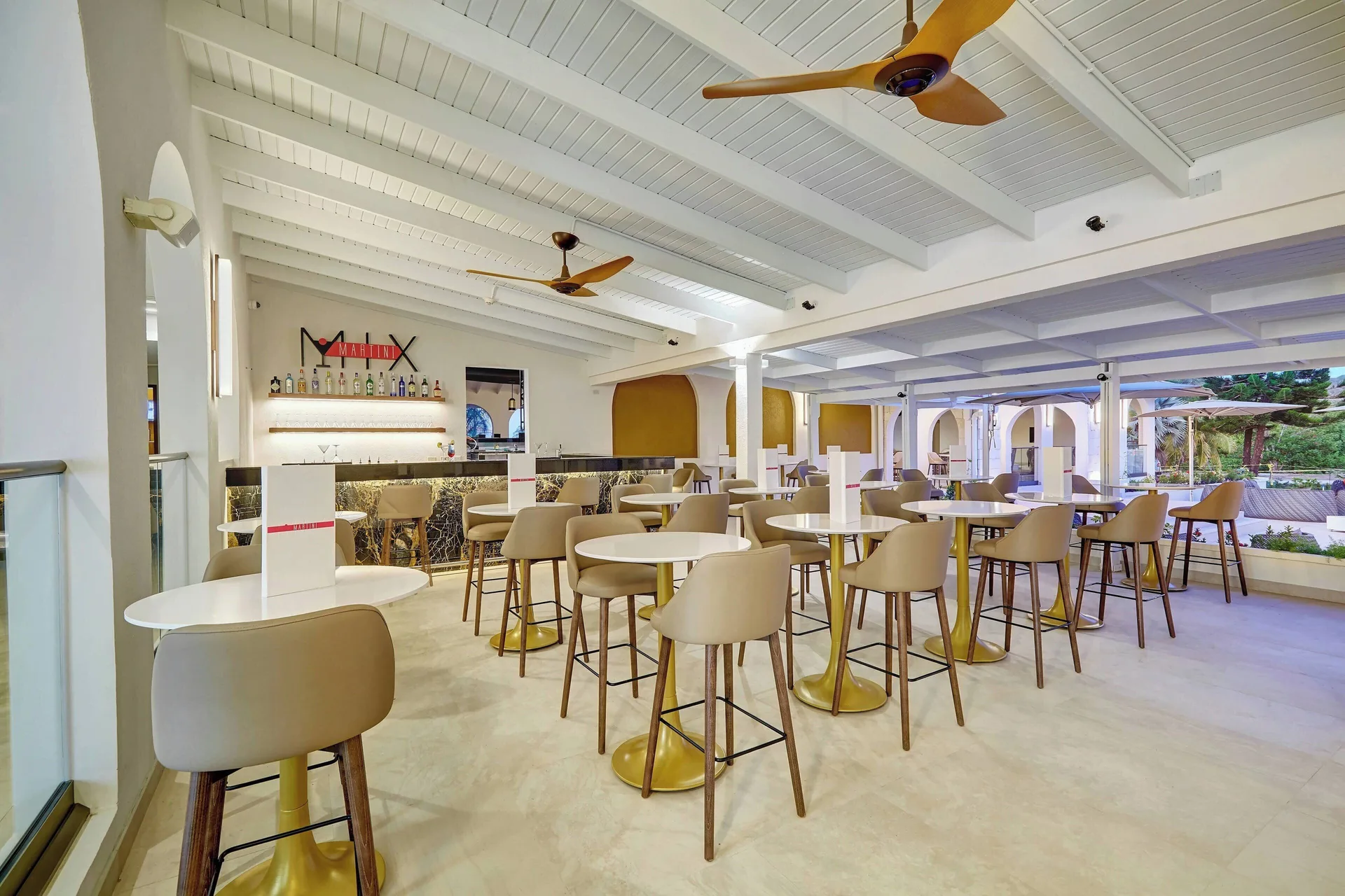 Bar lounge with high-top tables and a Martini Mix sign at Royalton Grenada.