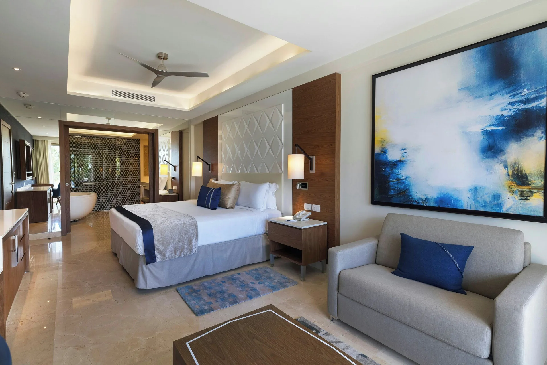 Chairman Two Bedroom Suite bedroom with king bed and sofa at Royalton Grenada.