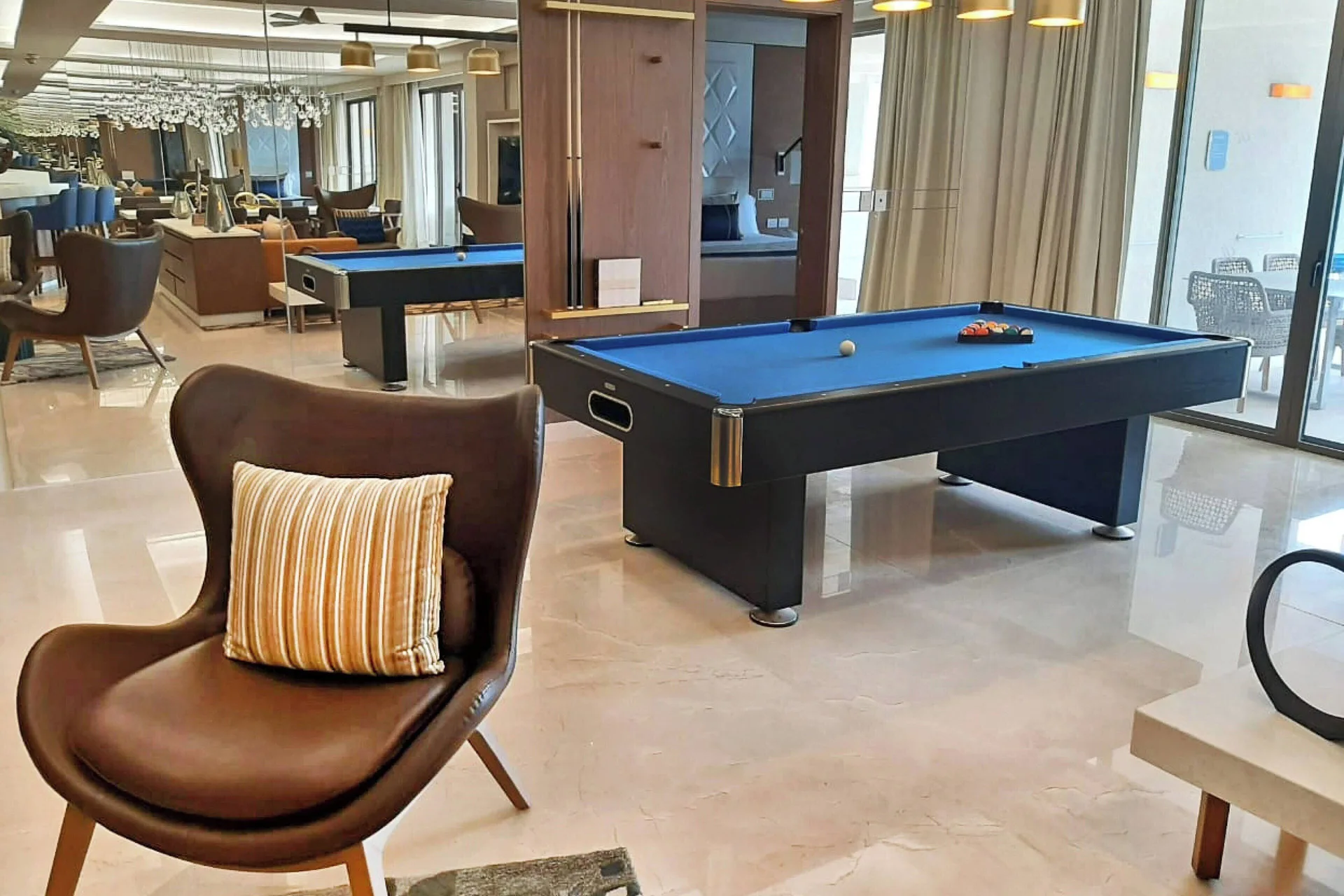 Suite lounge with blue-felt pool table and balcony doors at Royalton Grenada.