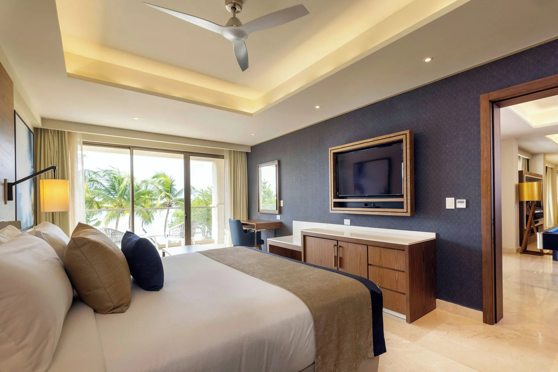 Oceanfront suite king bedroom with TV wall and balcony at Royalton Grenada.