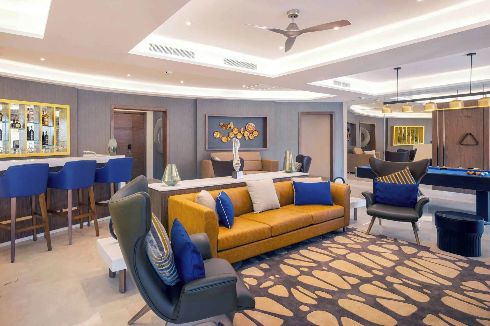 Large suite living room with sofa, bar, and pool table at Royalton Grenada.