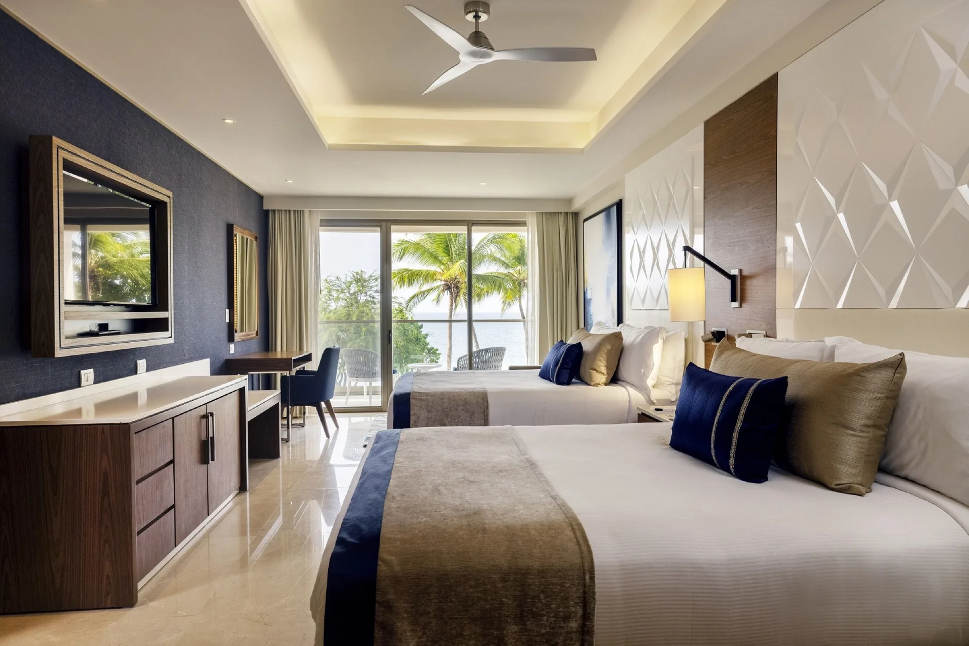 Two-bed oceanfront suite bedroom with balcony view at Royalton Grenada.