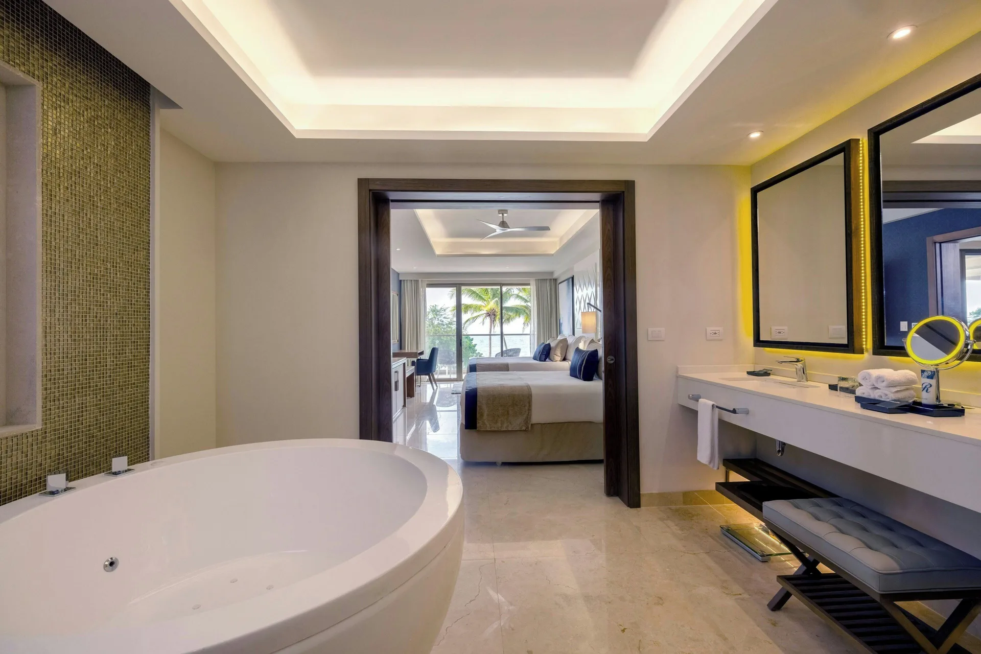 Suite bathroom with soaking tub, double vanity, and bedroom beyond at Royalton Grenada.