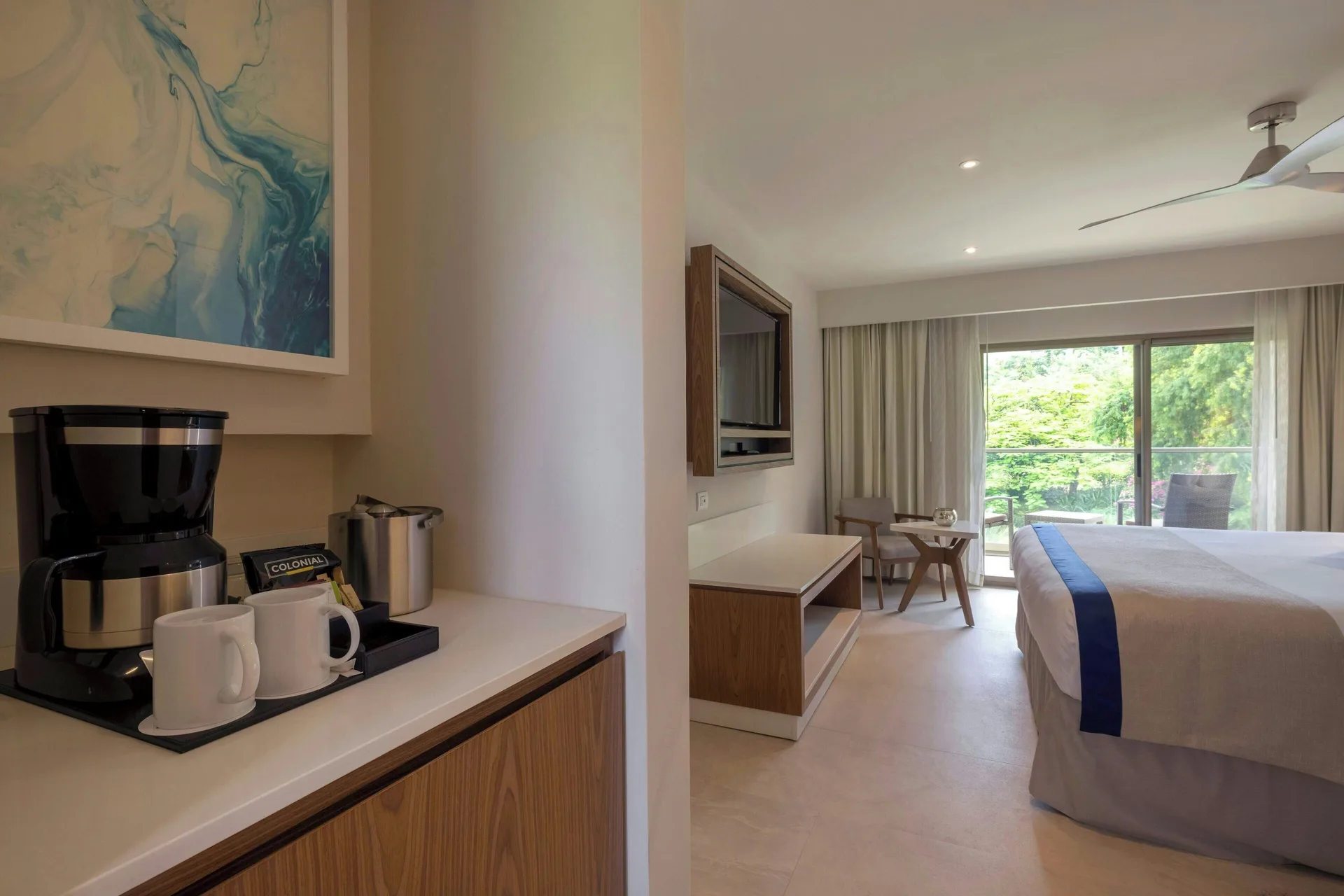 Suite king bedroom with coffee setup and garden-facing balcony at Royalton Grenada.