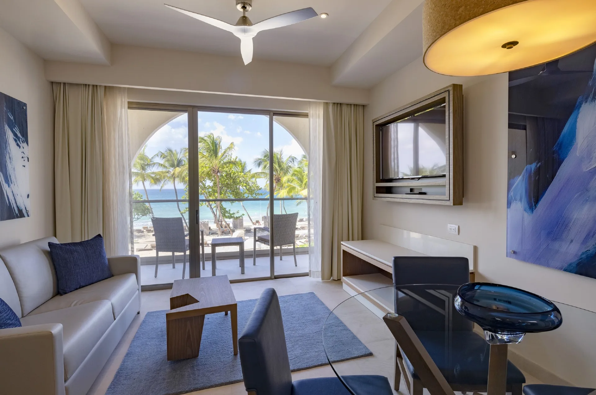 Living area of a Presidential Ocean Front One Bedroom Suite at Royalton Grenada with balcony and sea view.