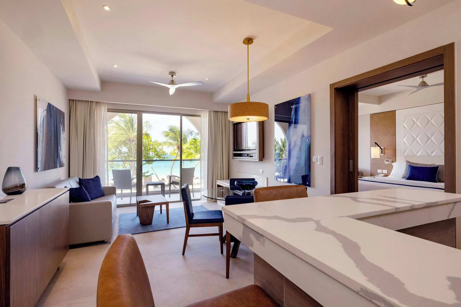 Suite living and dining area with balcony view and bedroom doorway at Royalton Grenada.