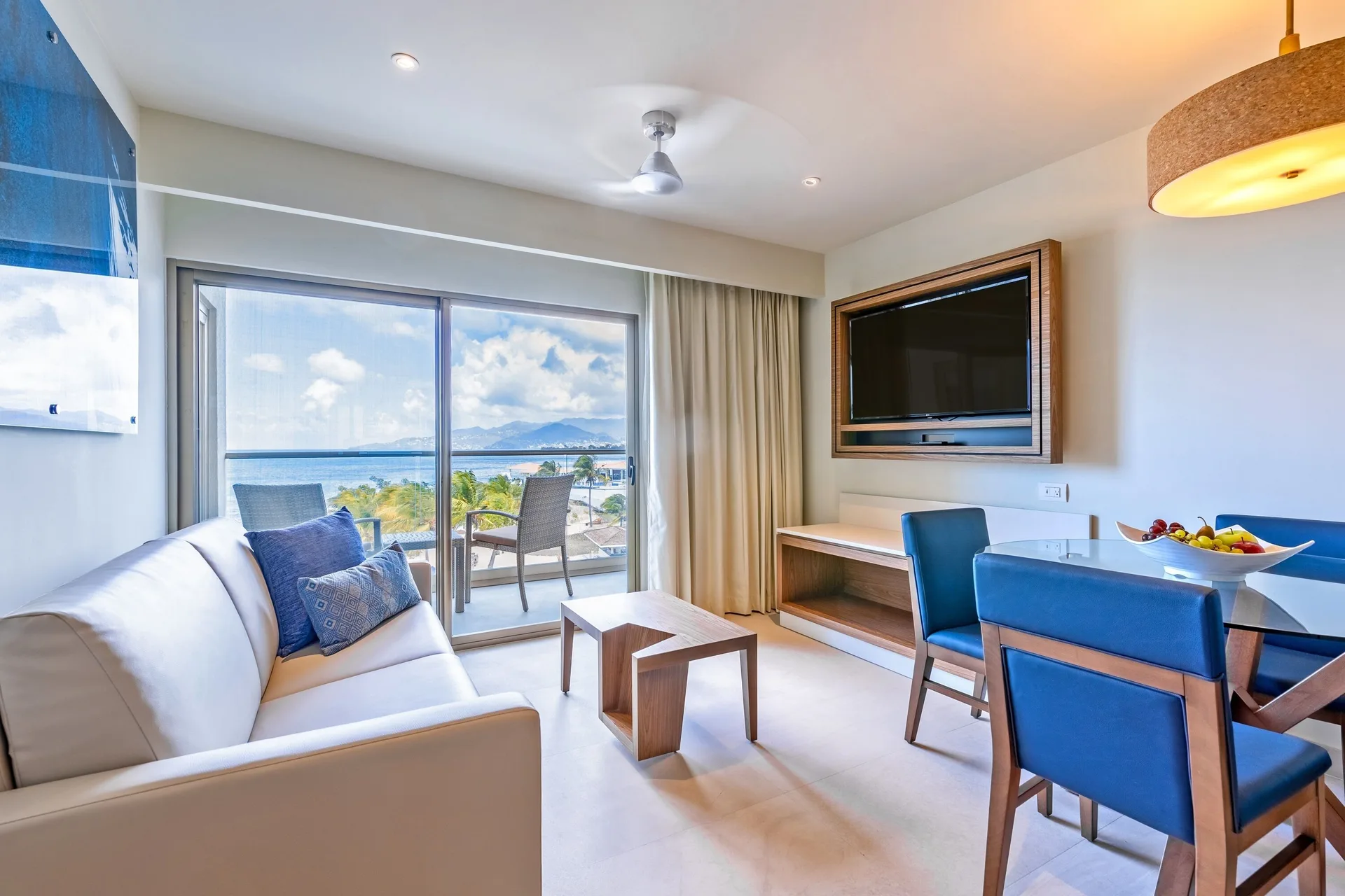 Presidential Ocean Front One Bedroom Suite sitting area at Royalton Grenada with dining table and balcony view.
