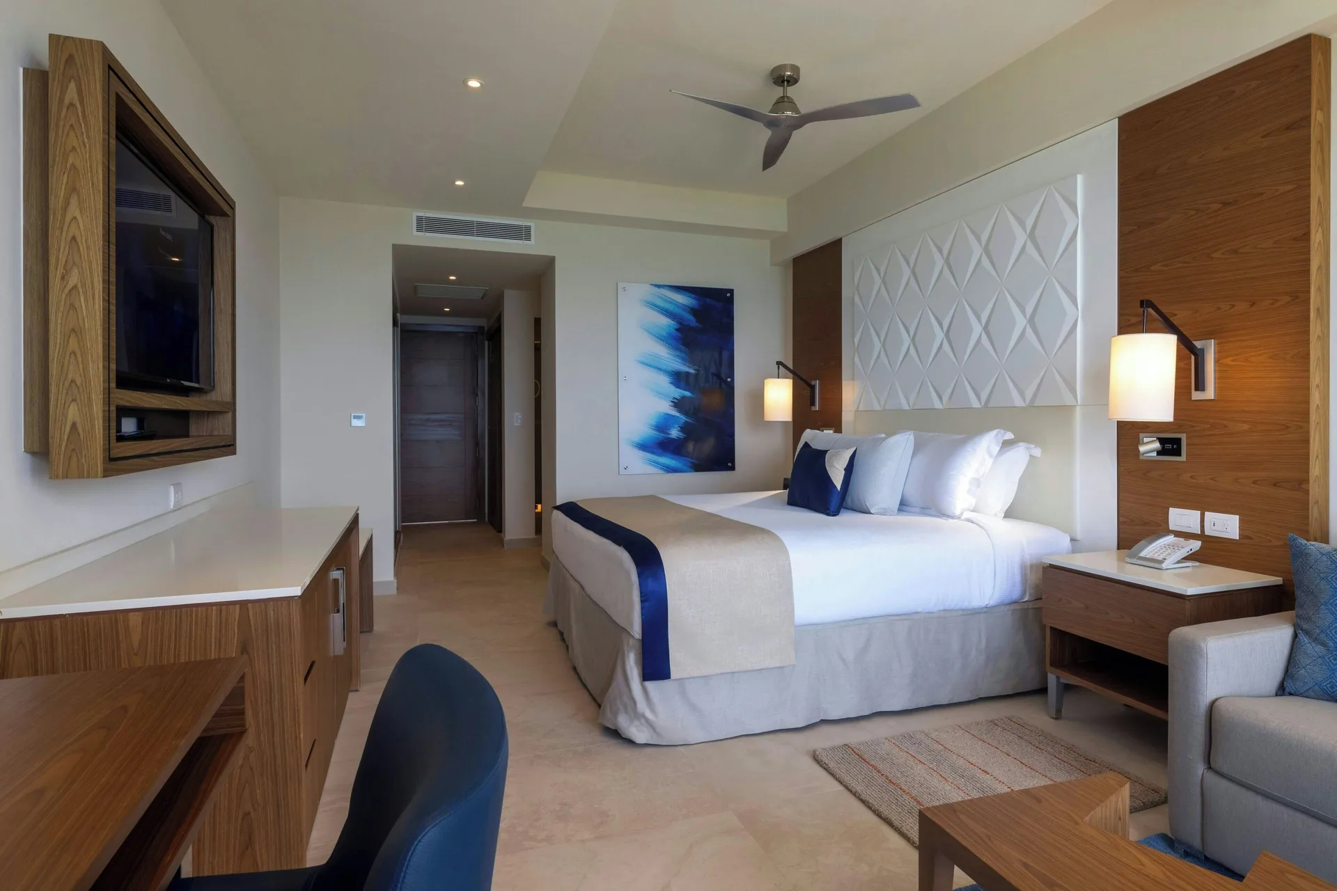 Luxury Room king bed with sitting area and desk at Royalton Grenada.