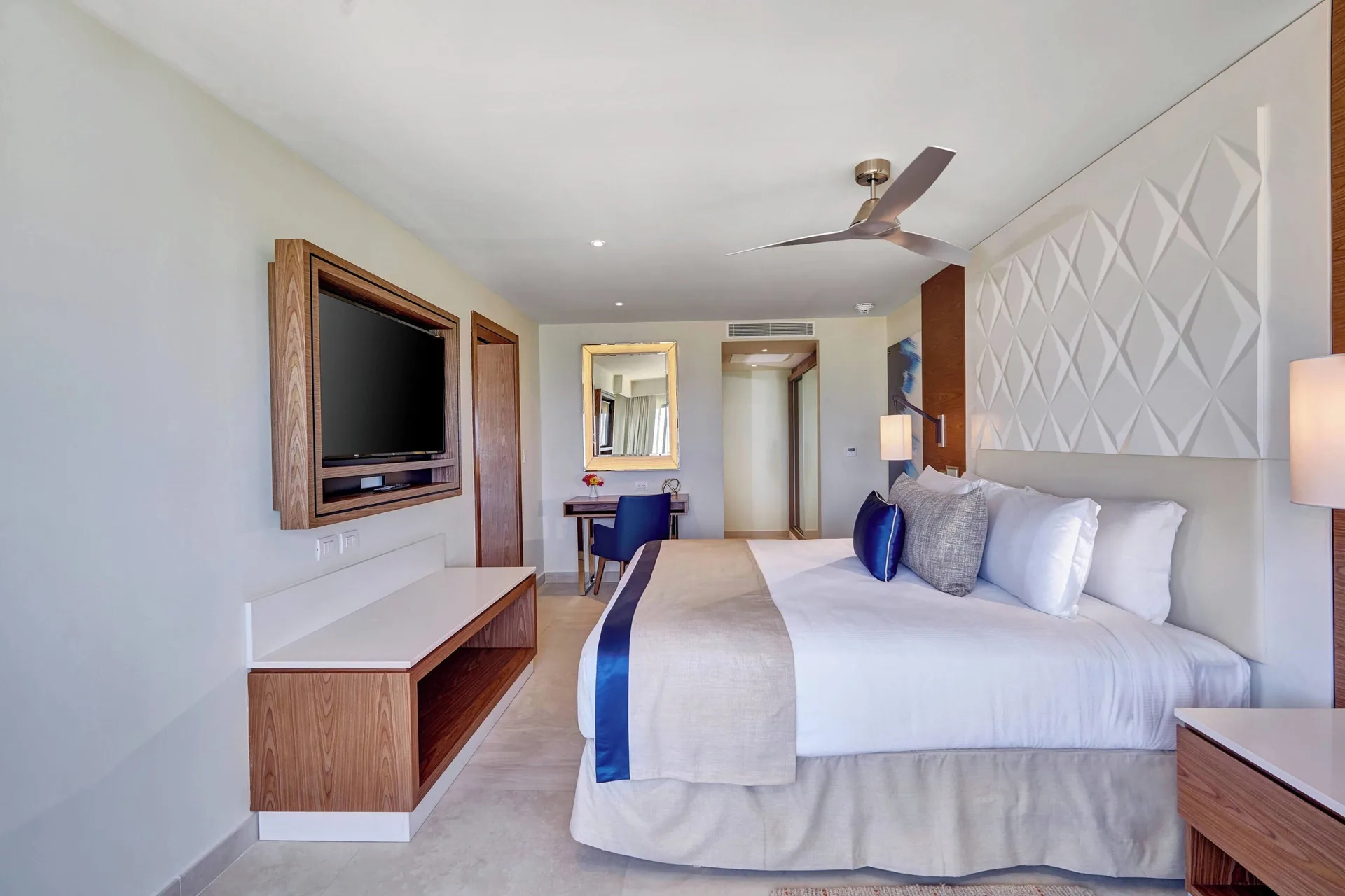 Luxury Room king bed with TV console and desk at Royalton Grenada.