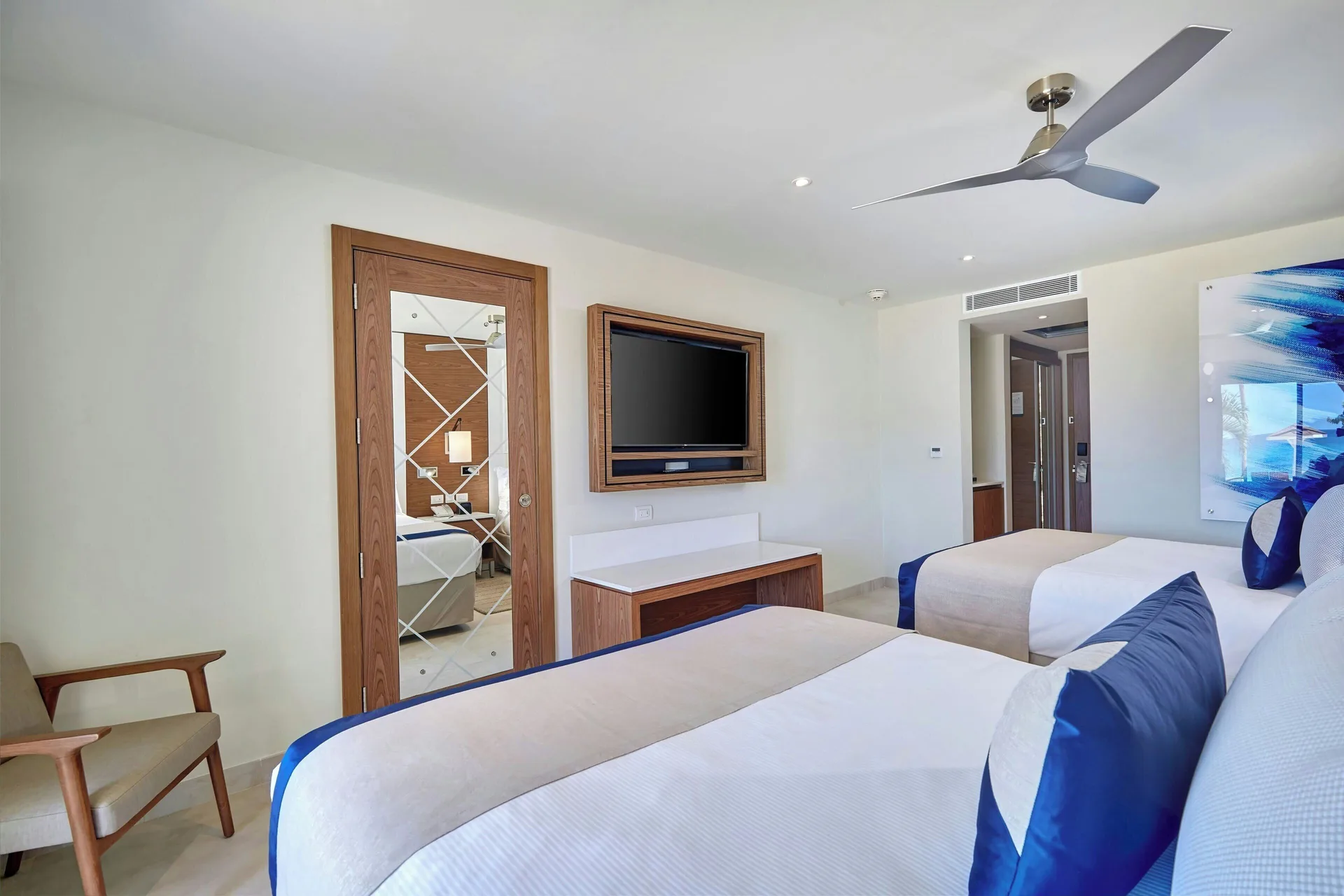Luxury Room with two beds, TV and mirrored closet at Royalton Grenada.