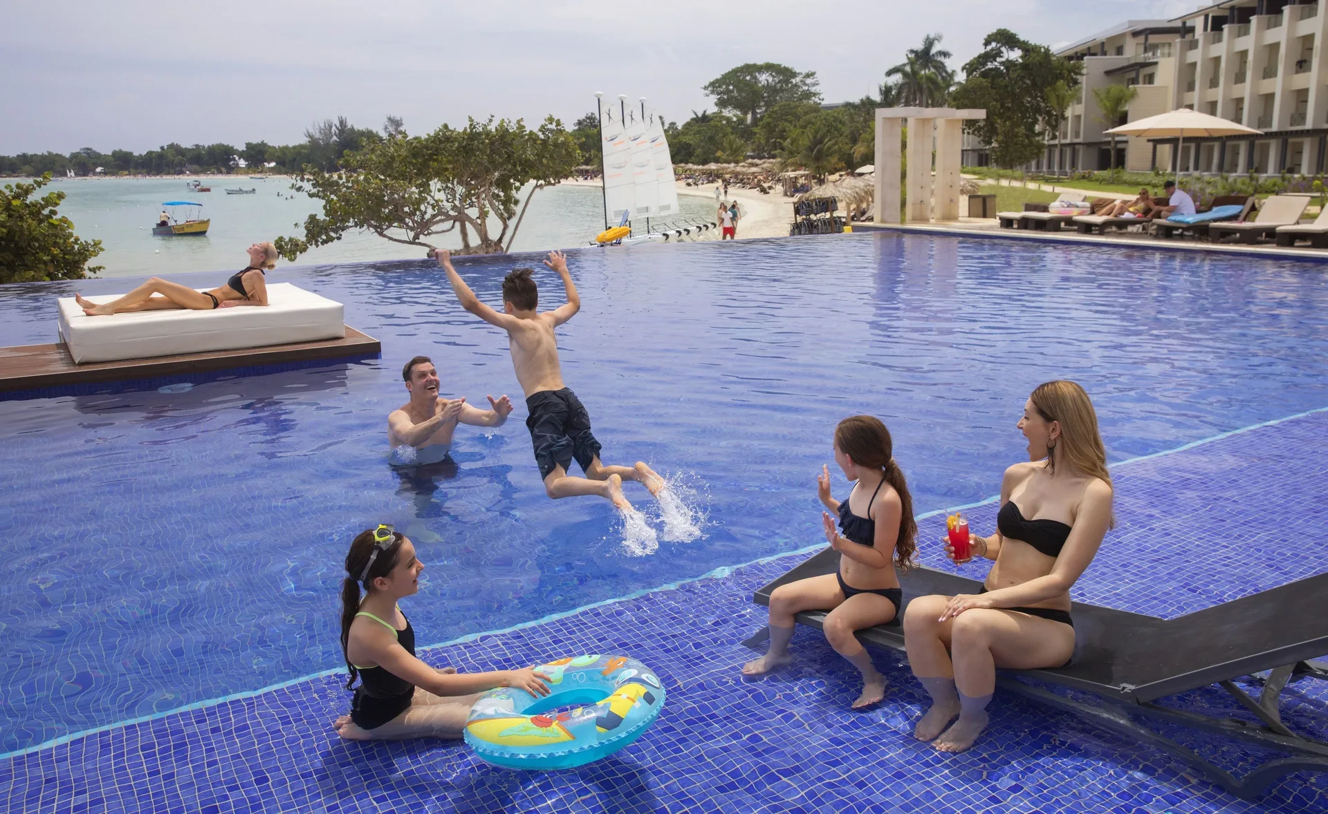 Family playing in a beachfront pool at Royalton Negril.
