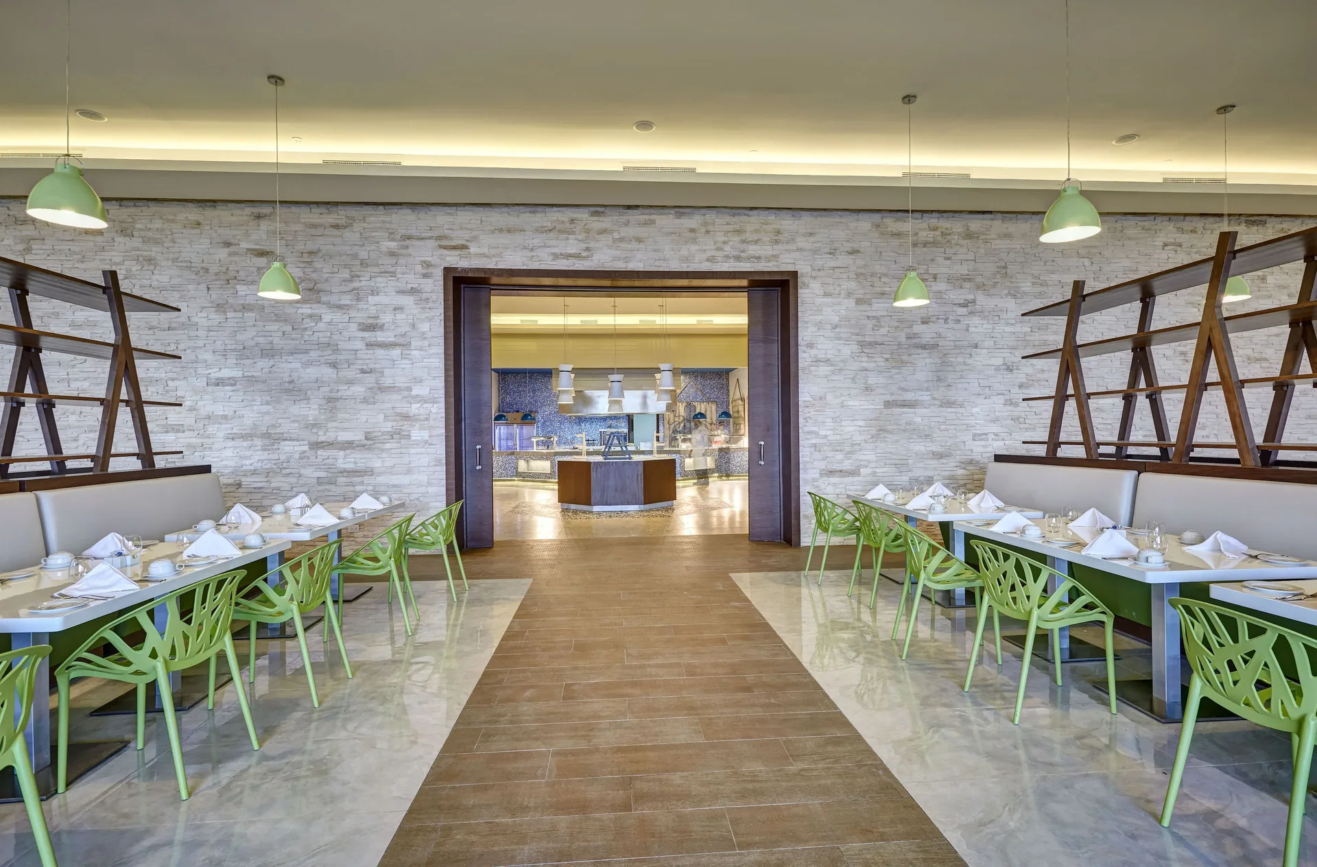 Bright buffet-style dining room with green chairs at Royalton Negril.