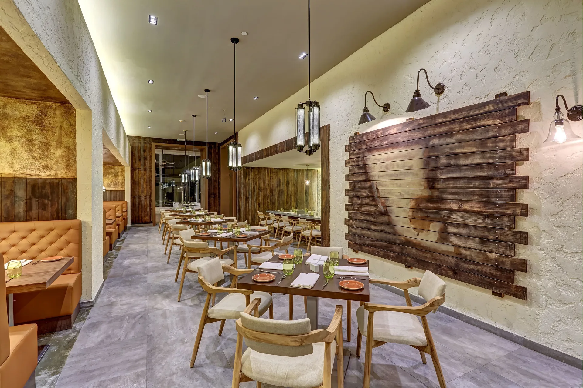 Rustic restaurant dining room with wood art and set tables at Royalton Negril.