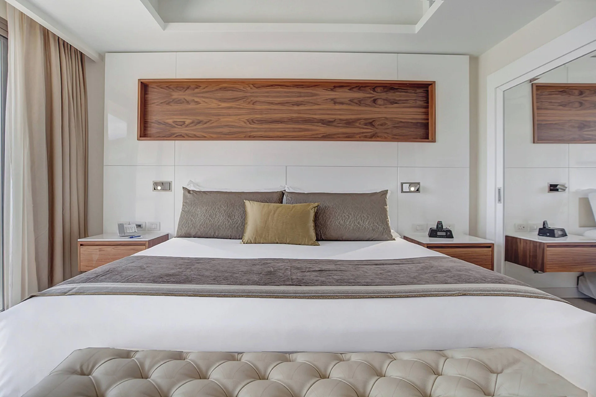 Luxury Family Suite Ocean View king bed with tufted bench at Royalton Negril.