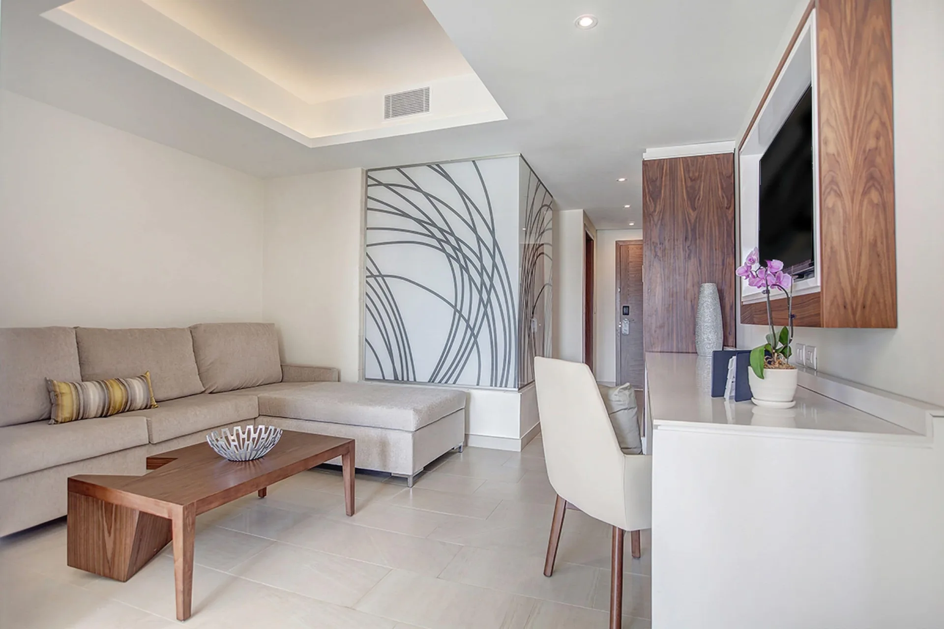 Luxury Family Suite Ocean View living area with desk and wall-mounted TV at Royalton Negril.