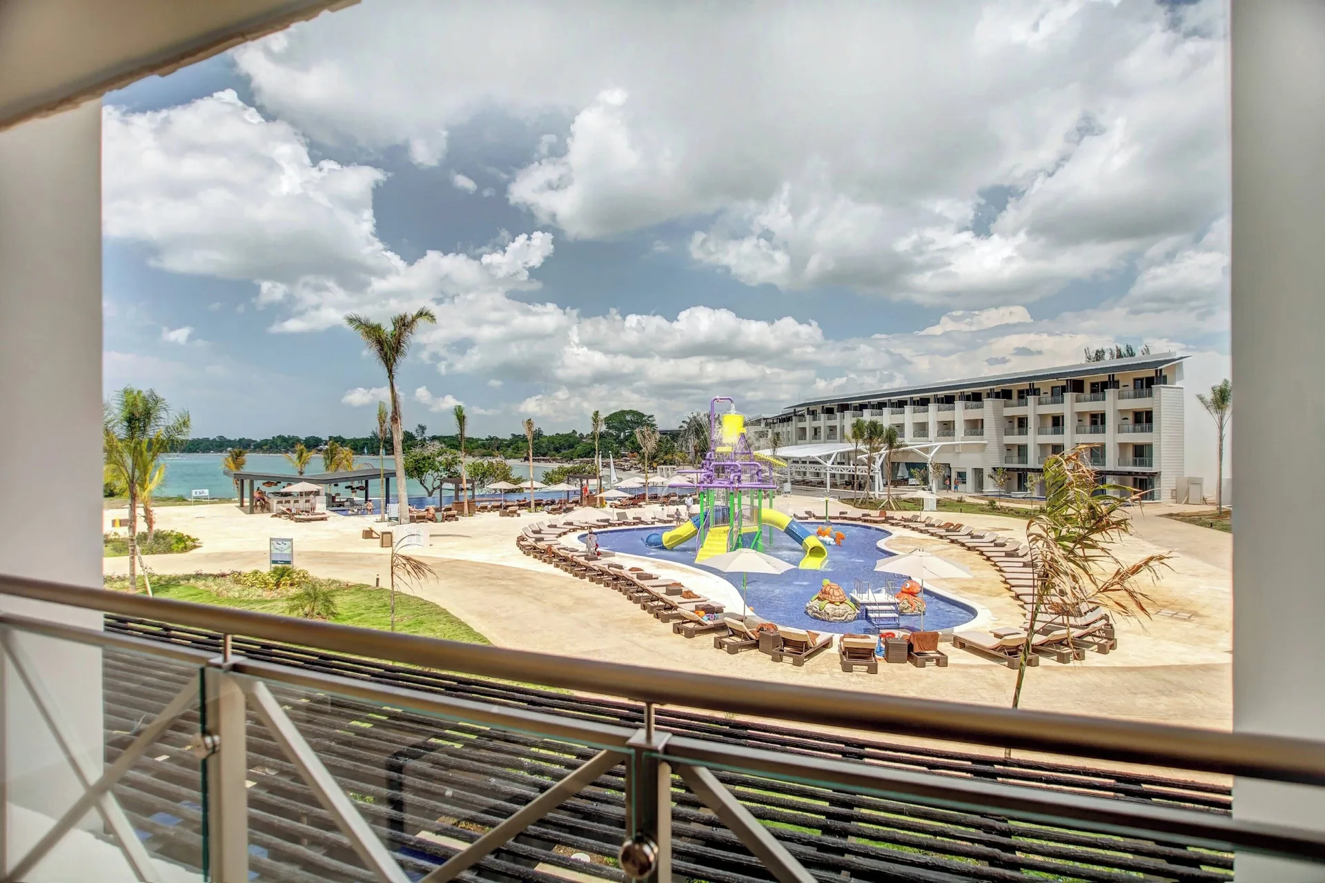 Luxury Junior Suite balcony view of pools and beachfront at Royalton Negril.