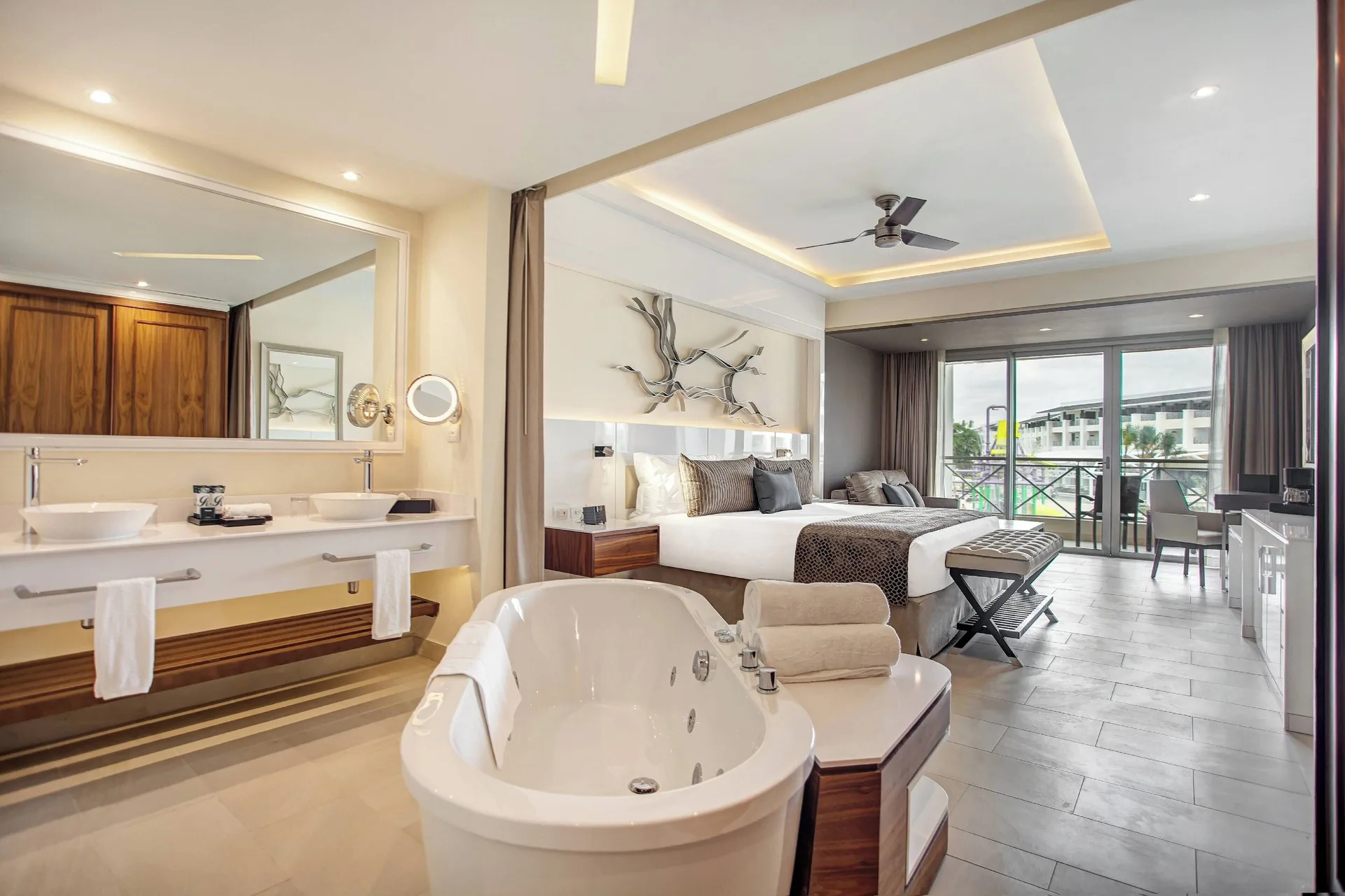 Luxury Junior Suite with soaking tub, vanity, king bed, and balcony at Royalton Negril.