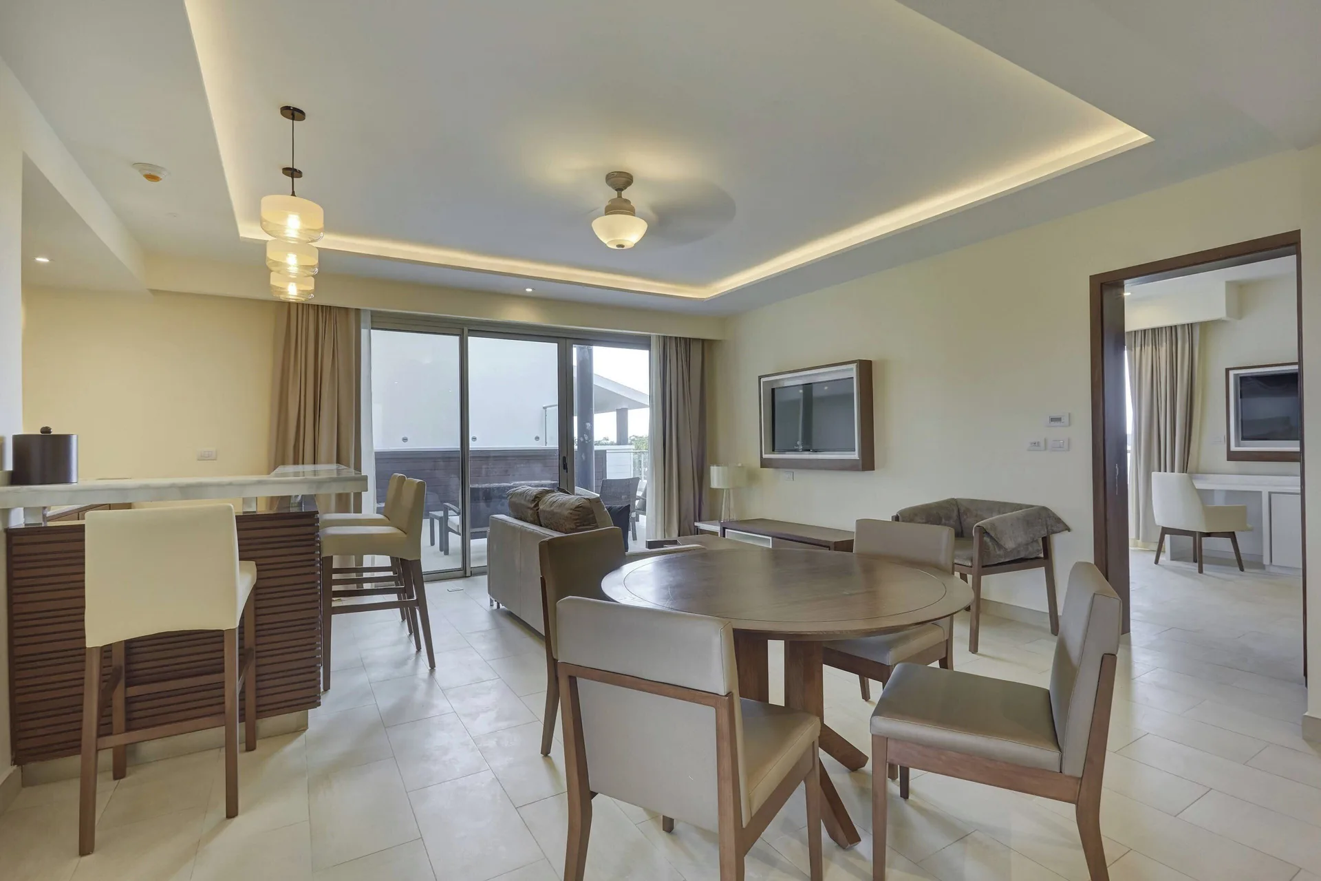 Suite living and dining area with bar seating and bedroom doorway at Royalton Negril.