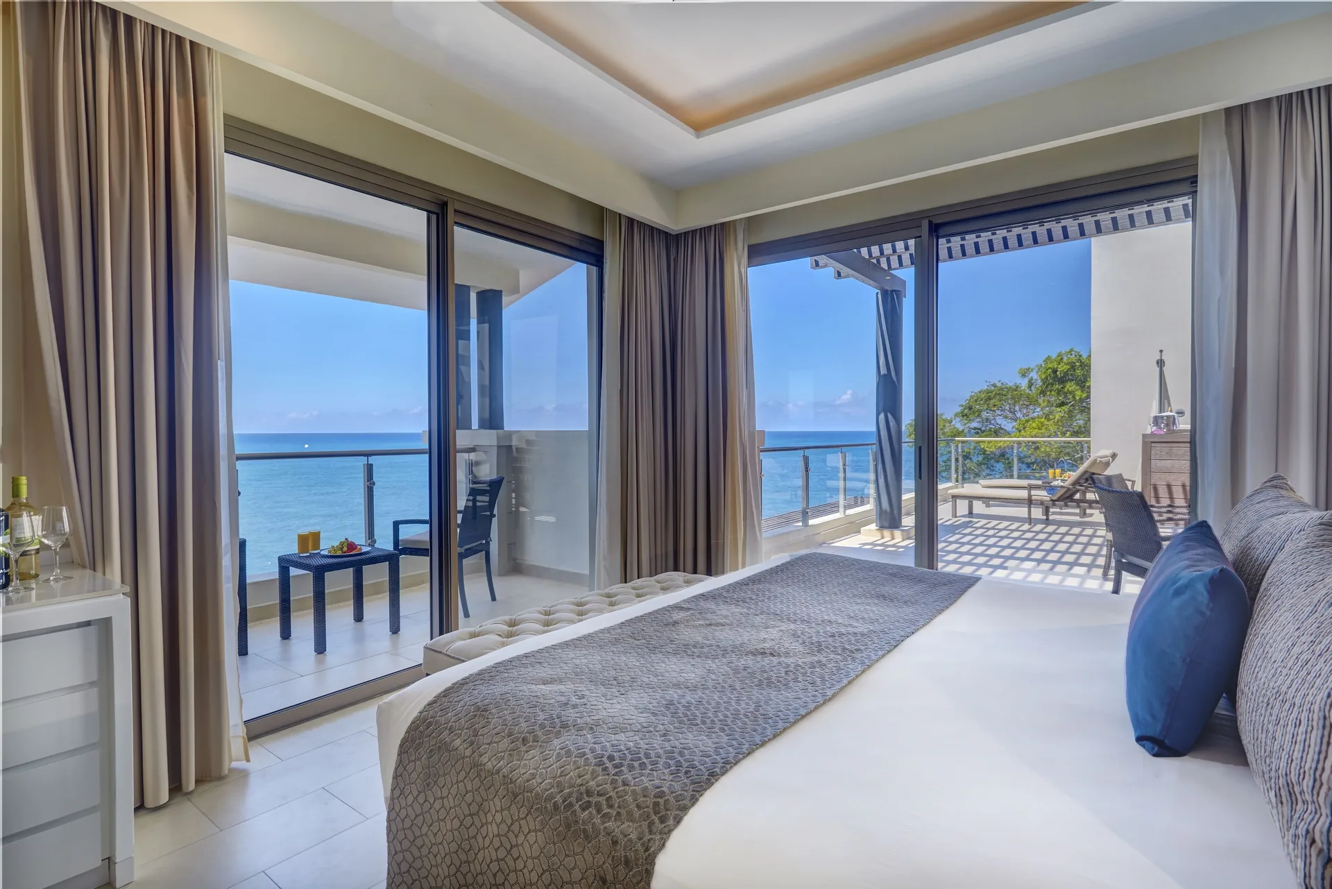 Penthouse suite king bed opening to ocean-view terraces at Royalton Negril.
