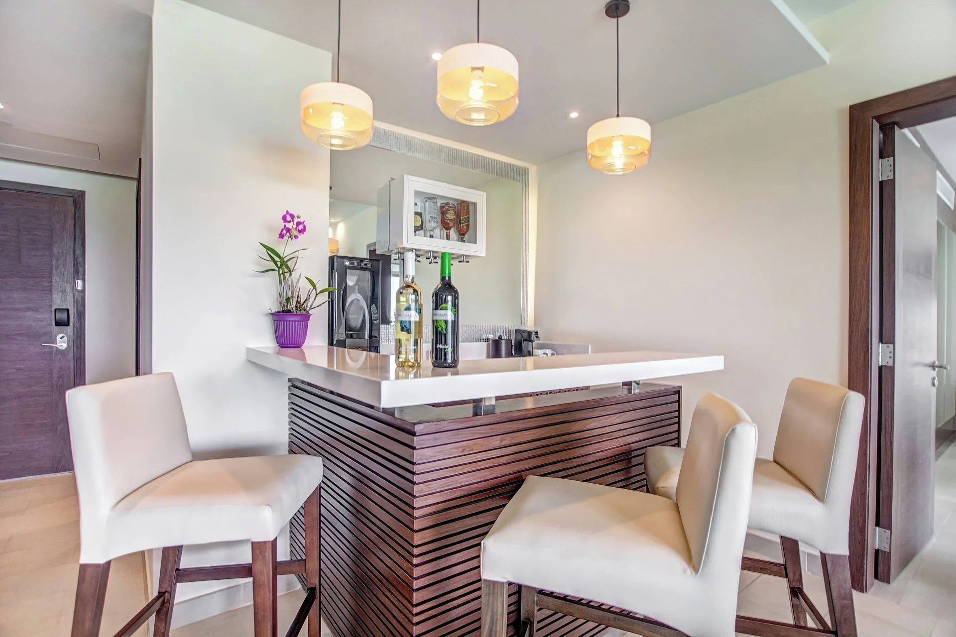 Close view of the wet bar with stools and pendant lights at Royalton Negril.