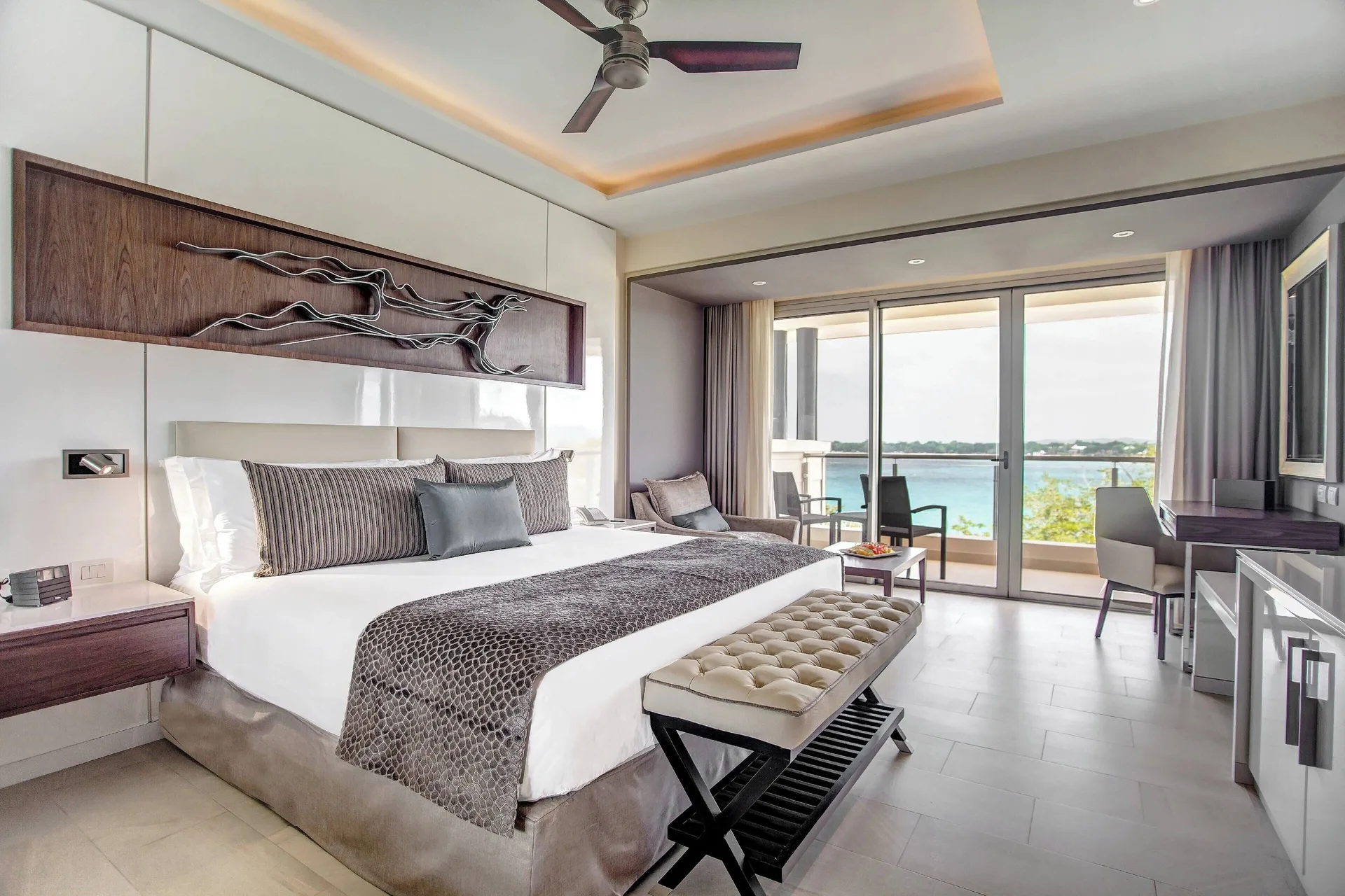 King bedroom with ocean-facing balcony in a Royalton Negril suite.