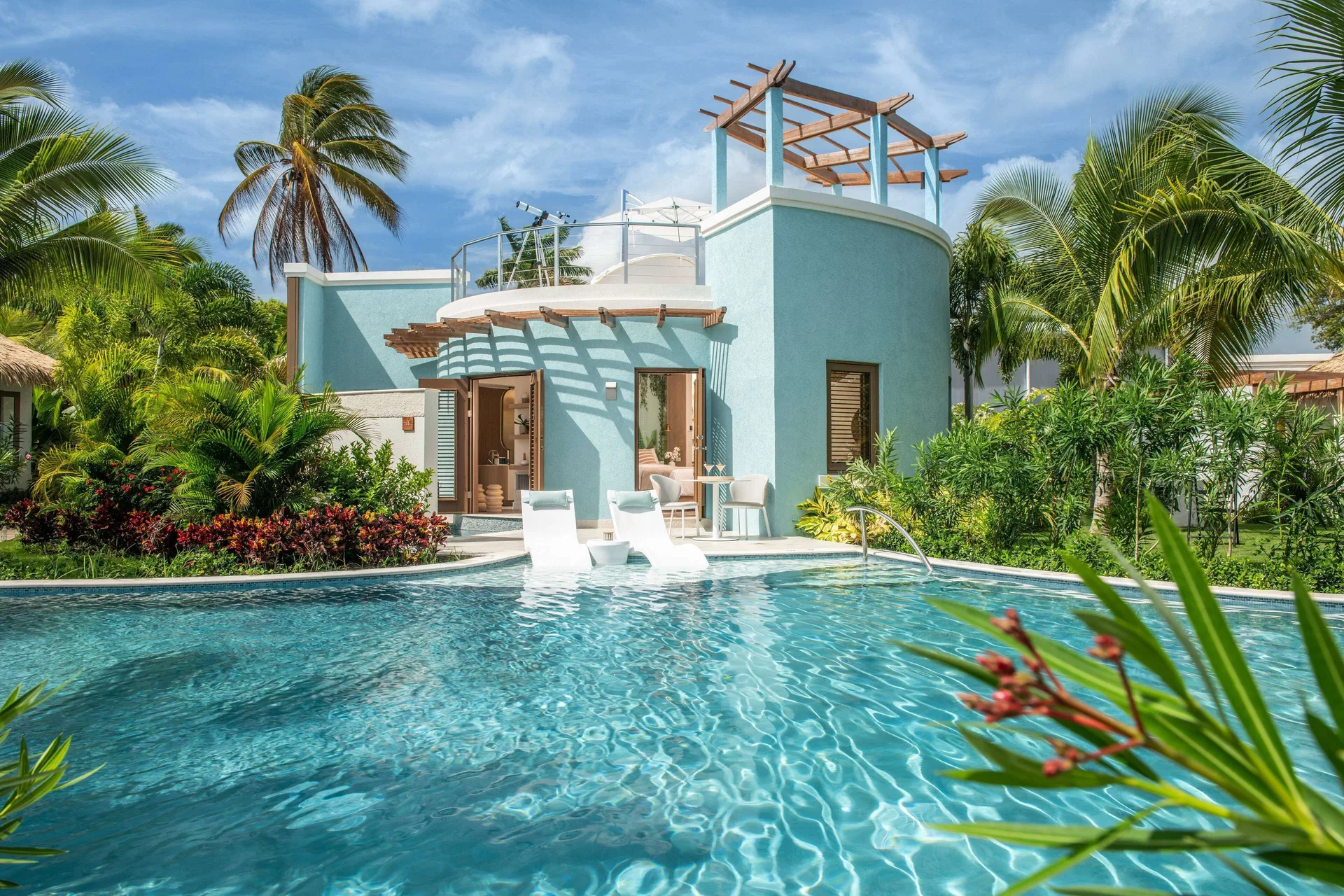 Private villa pool and aqua exterior surrounded by palms at Sandals Dunns River.