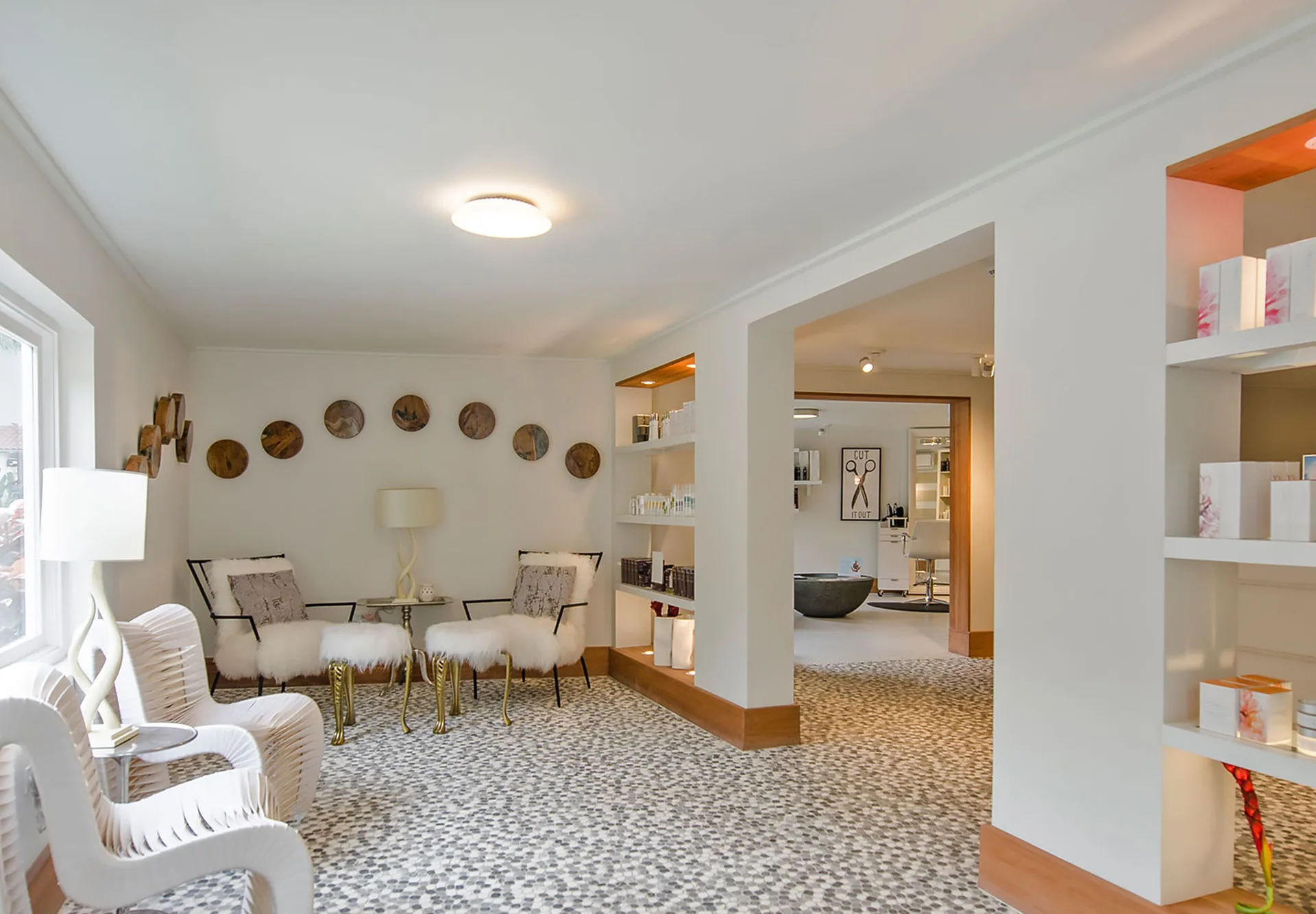 Spa waiting area with white chairs and product shelves at Sandals Dunns River.