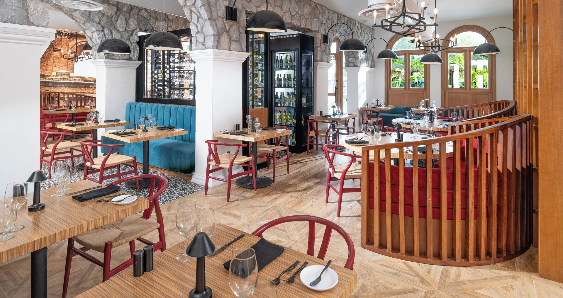 Restaurant dining room with red chairs and arched windows at Sandals Dunns River.