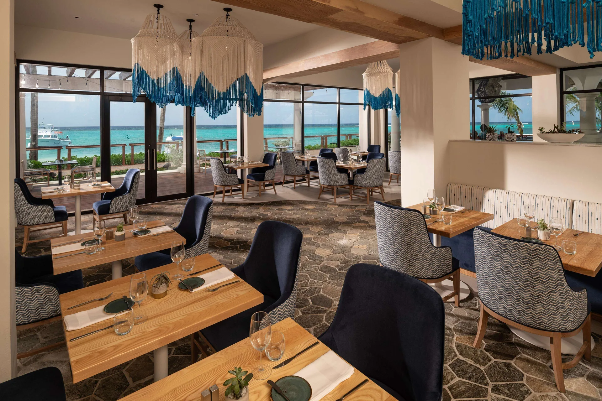 Seaside dining room with ocean-view windows at Sandals Dunns River.