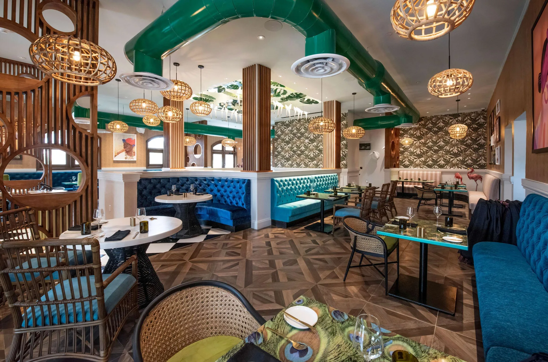 Colorful tropical dining room with blue booths and woven pendant lights at Sandals Dunns River.