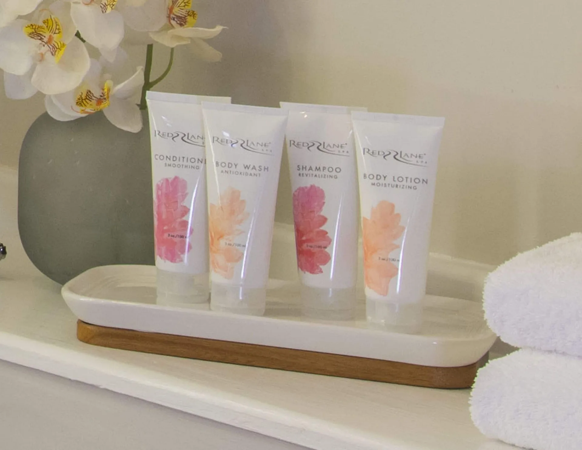 Luxury Room bath amenities with towels and flowers at Sandals Dunns River.