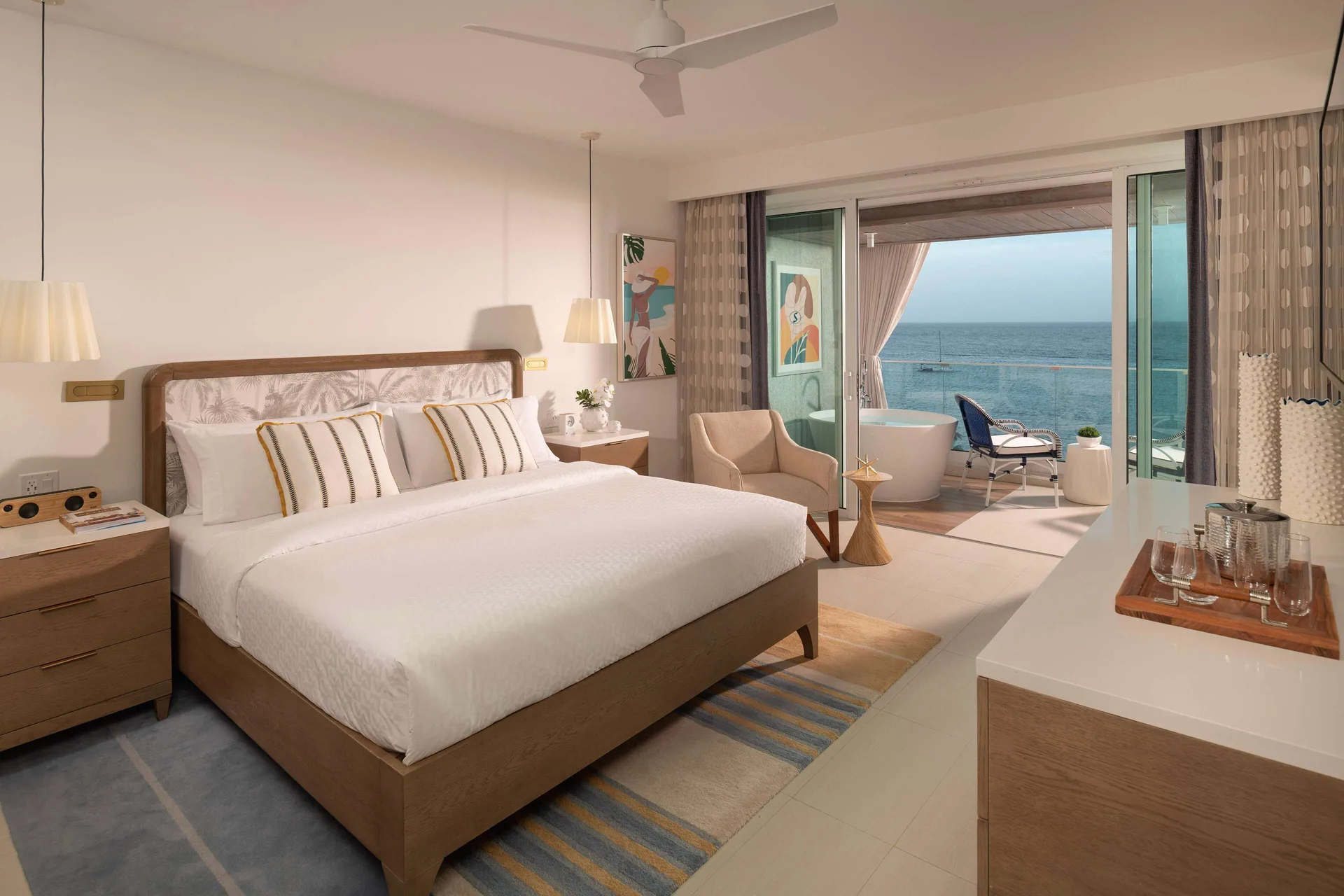 Luxury Room king bed and ocean-facing balcony at Sandals Dunns River.